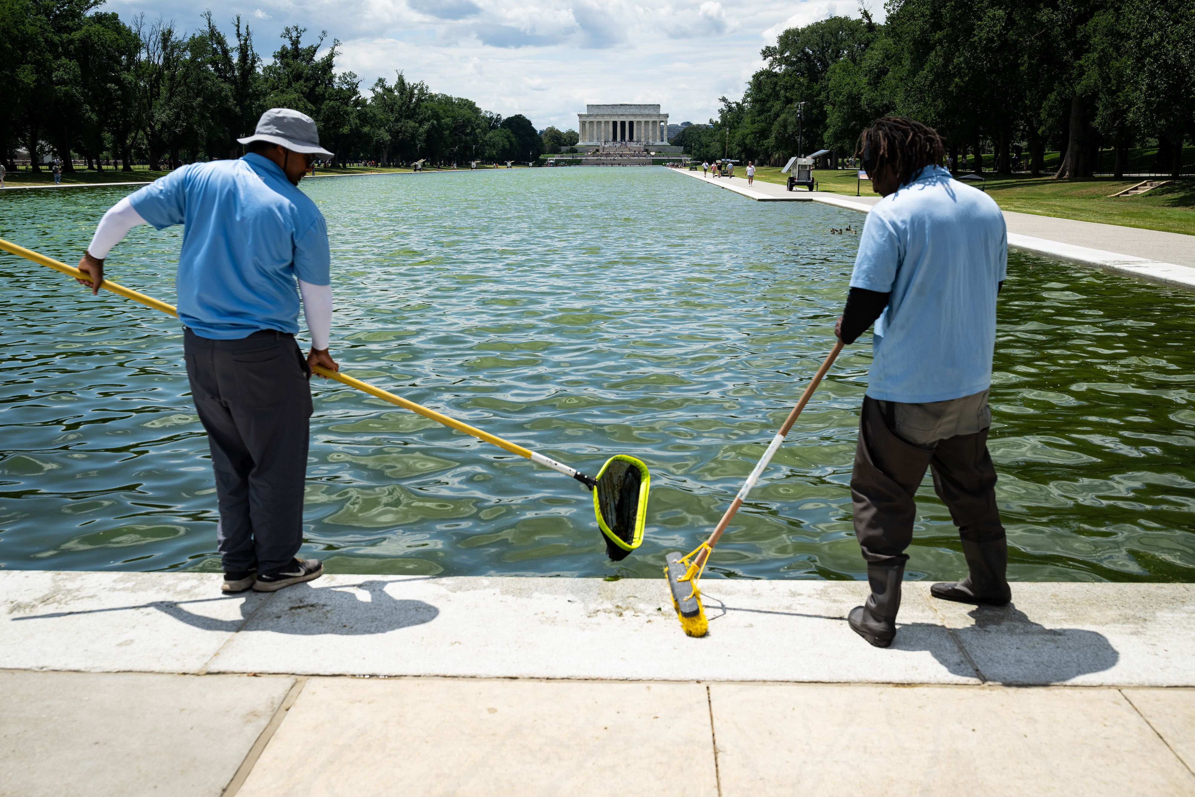Workers remove algae and debris from the Lincoln Memorial Reflecting Pool yesterday. Photo: Graeme Sloan/Bloomberg via Getty Images