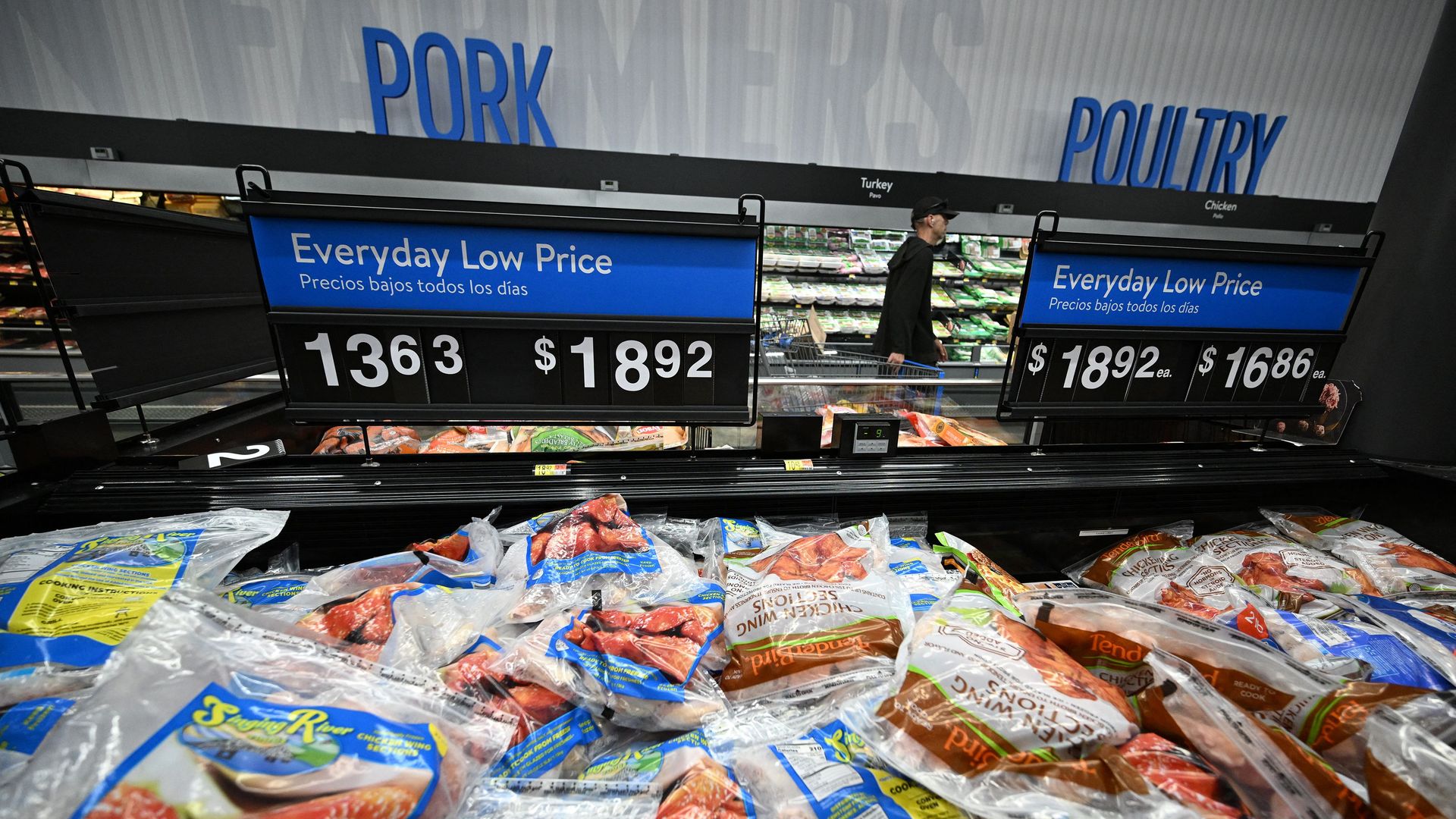 Pork and Poultry signs above a refrigerated meat department in Walmart