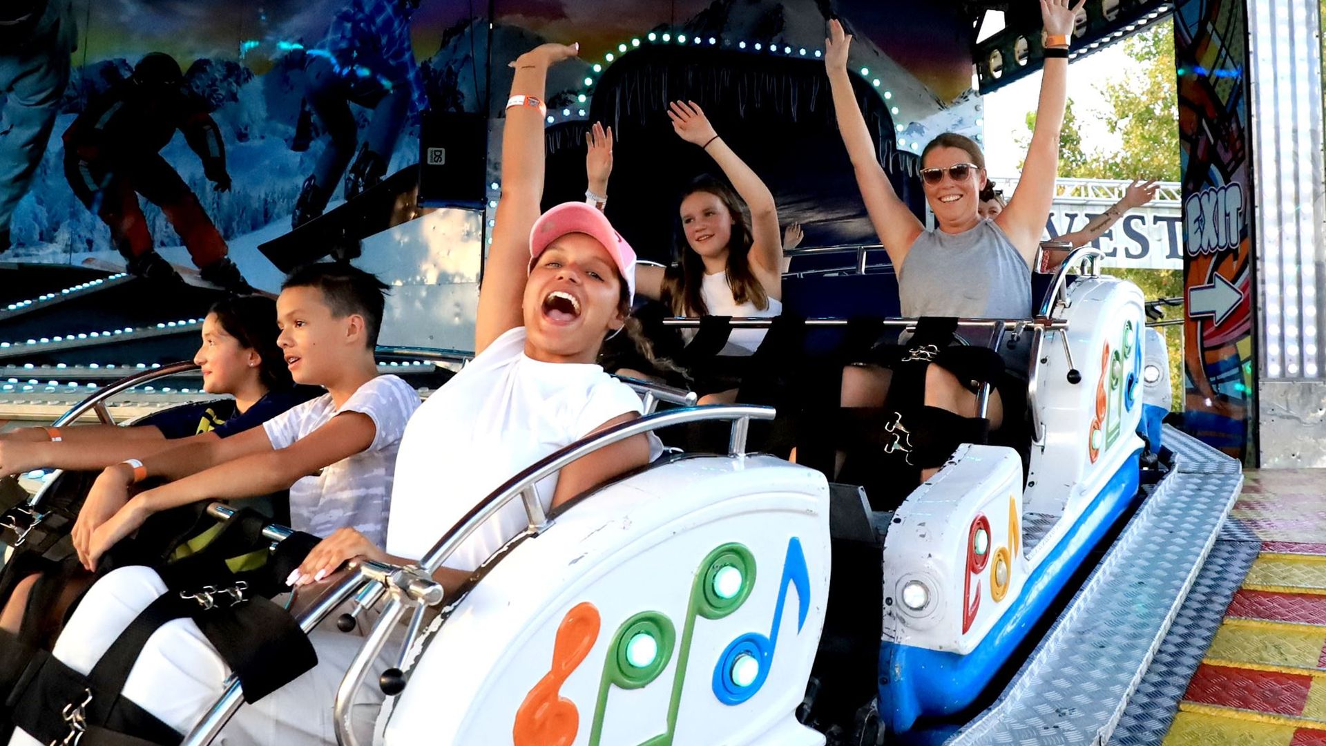 People smiling in roller coster cars.