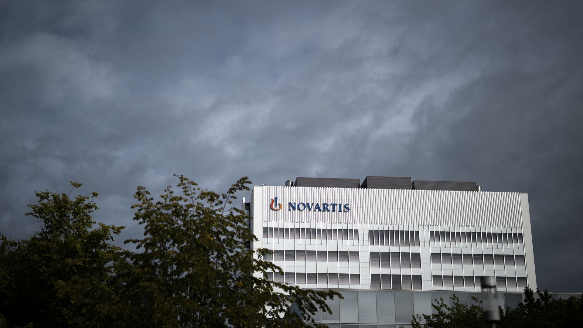 A sign of Swiss pharmaceutical giant Novartis is seen on the top of a building at Novartis Campus in Basel, northern Switzerland, on September 9, 2025. US President Trump is pressuring the Swiss pharmaceutical industry to lower its prices in the United States and move its production there, threateni