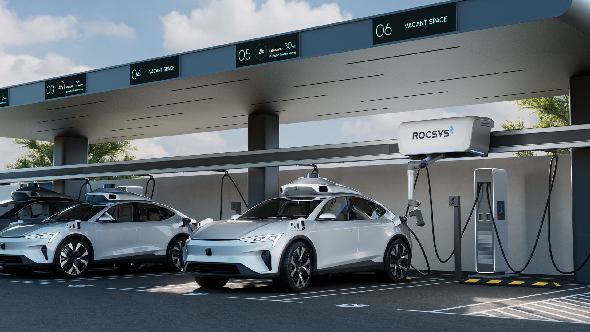 Modern electric vehicle charging station with white cars in bays under a gray canopy. Digital panels show bay numbers 03–06, and how much charging time is left for each; a ROCSYS robotic charger is mounted overhead.