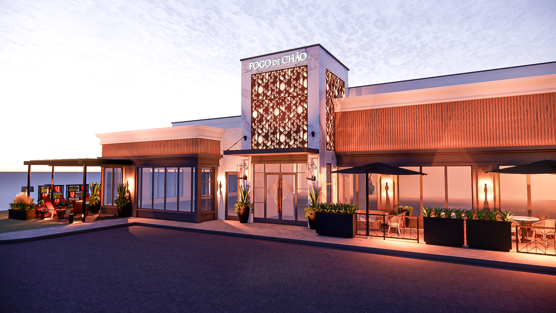 A well lit, modern restaurant exterior with planters in front 