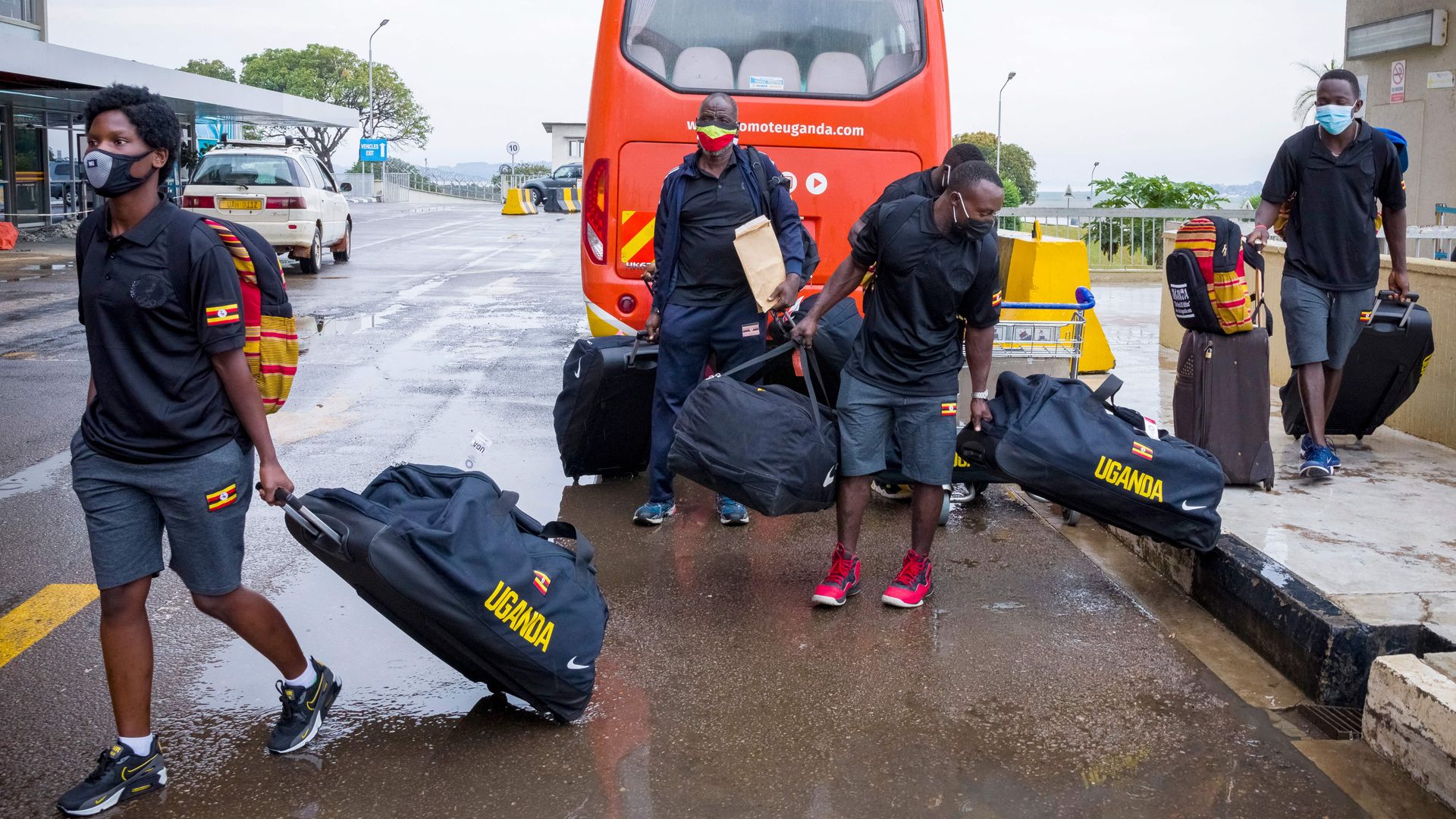 The Uganda National boxing team's Catherine Nanziri (L) and other arrive for check-in with their baggage at Entebbe international airport in Wakiso, Uganda on June 18