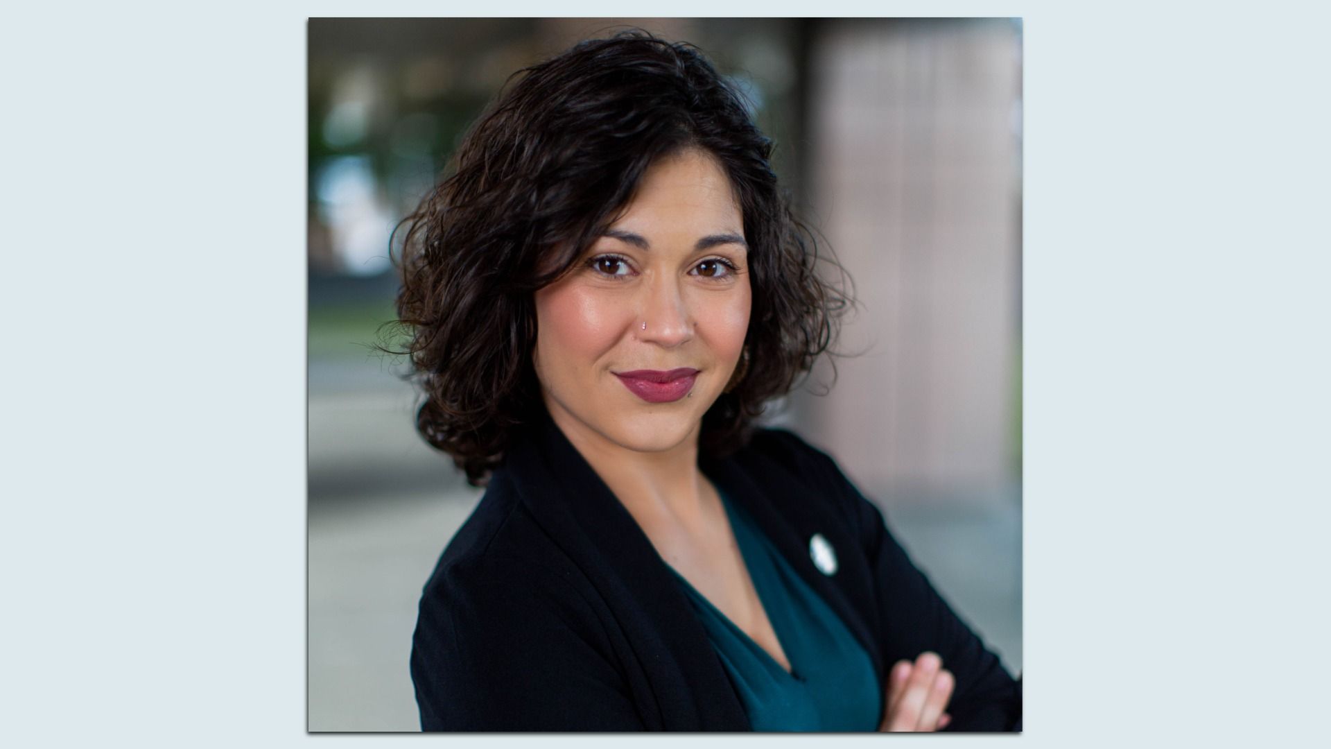 Renton Councilmember looks at the camera while slightly smiling. The photo of her is mounted on a light blue background.