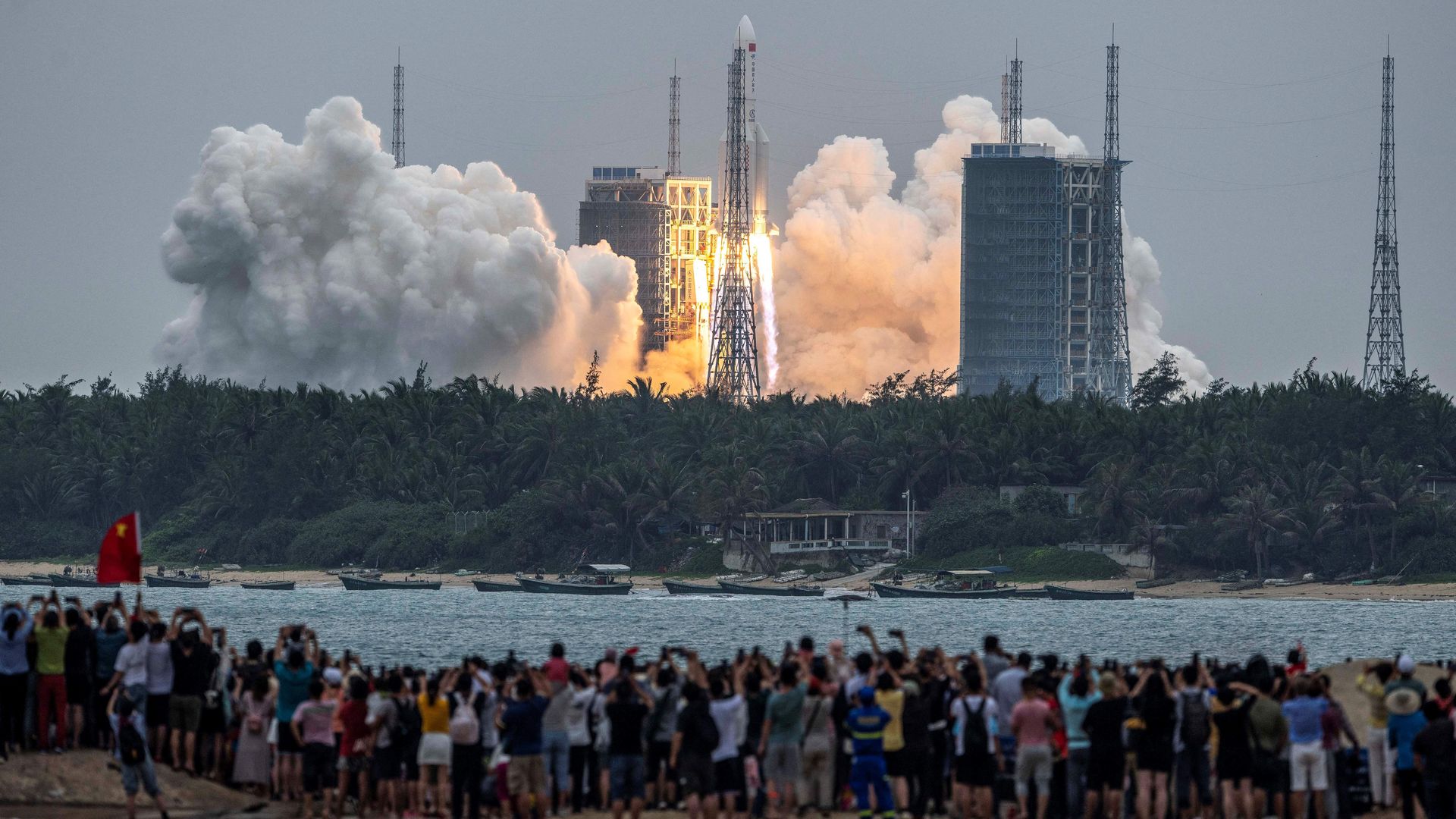  People watch a Long March 5B rocket, carrying China's Tianhe space station core module, as it lifts off from the Wenchang Space Launch Center in southern China's Hainan province on April 29