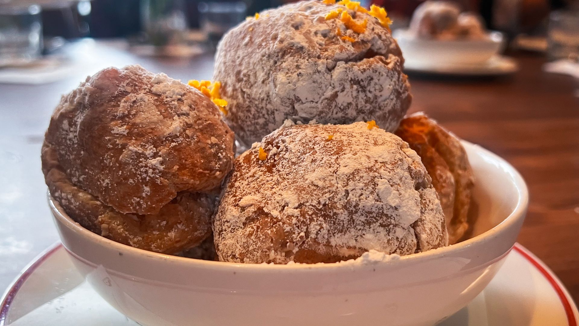 A bowl of powdered, round pastries. 