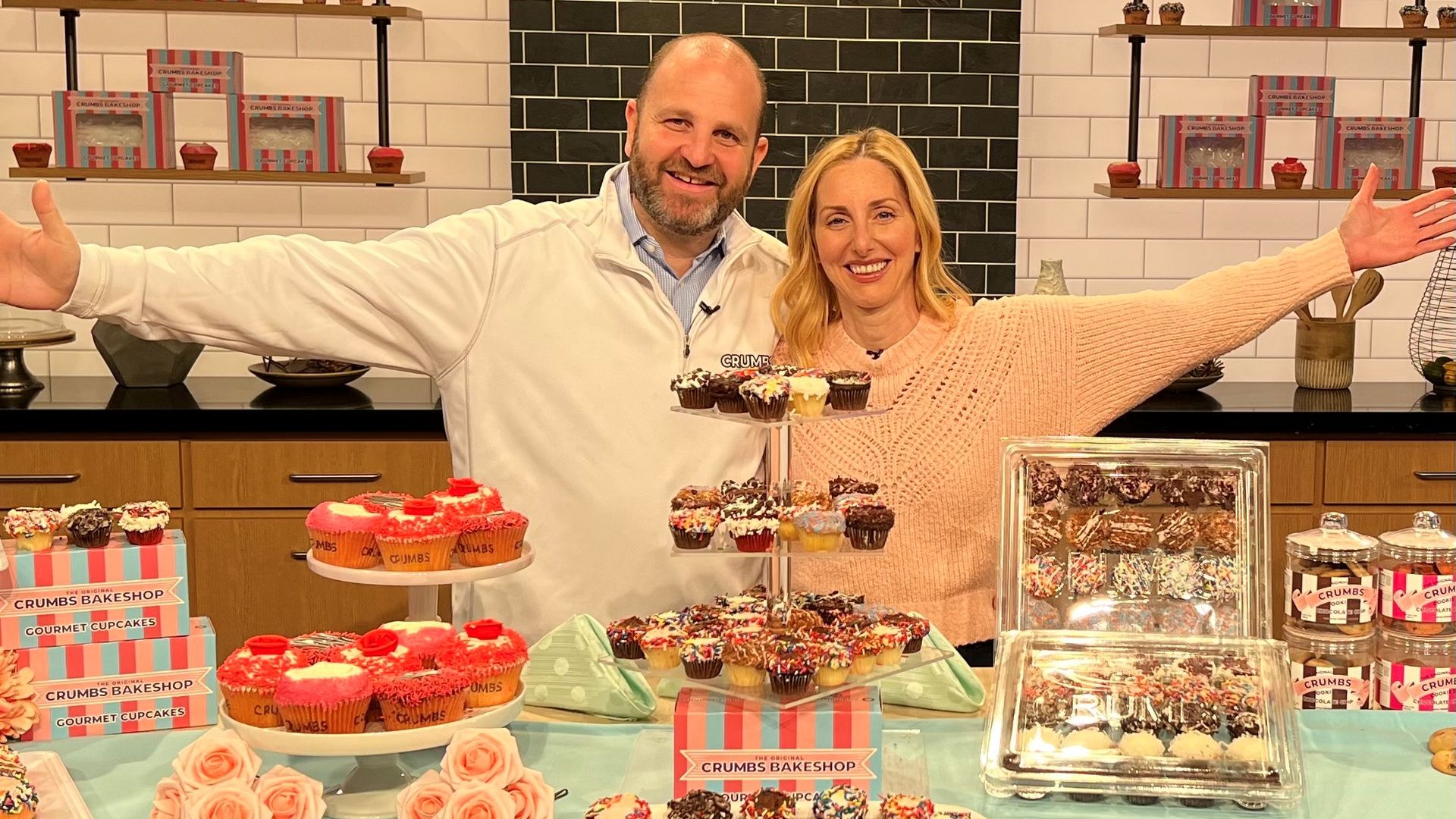 Jason and Mia Bauer, the founders of Crumbs, stand behind a product display.