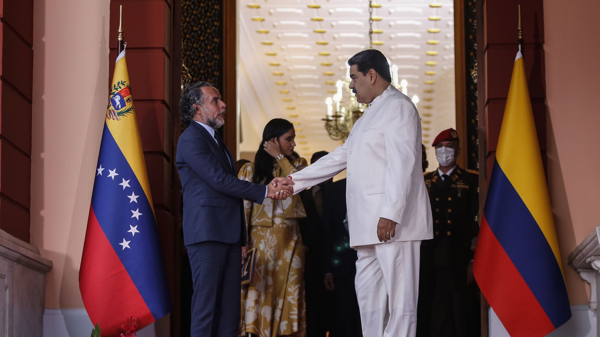 Colombia's new ambassador to Venezuela, Armando Benedetti, shakes hands with Venezuela President Nicolas Maduro