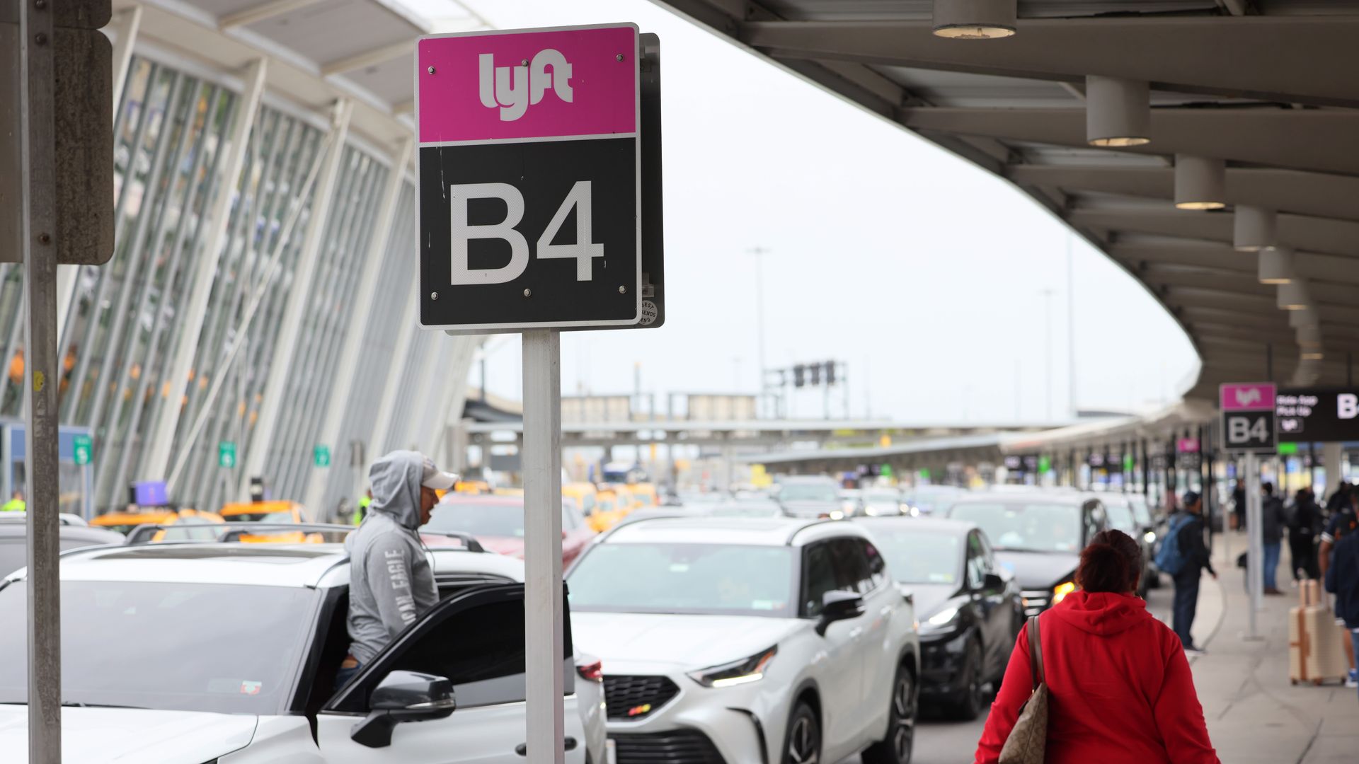 Vehicles await passengers at an airport curb