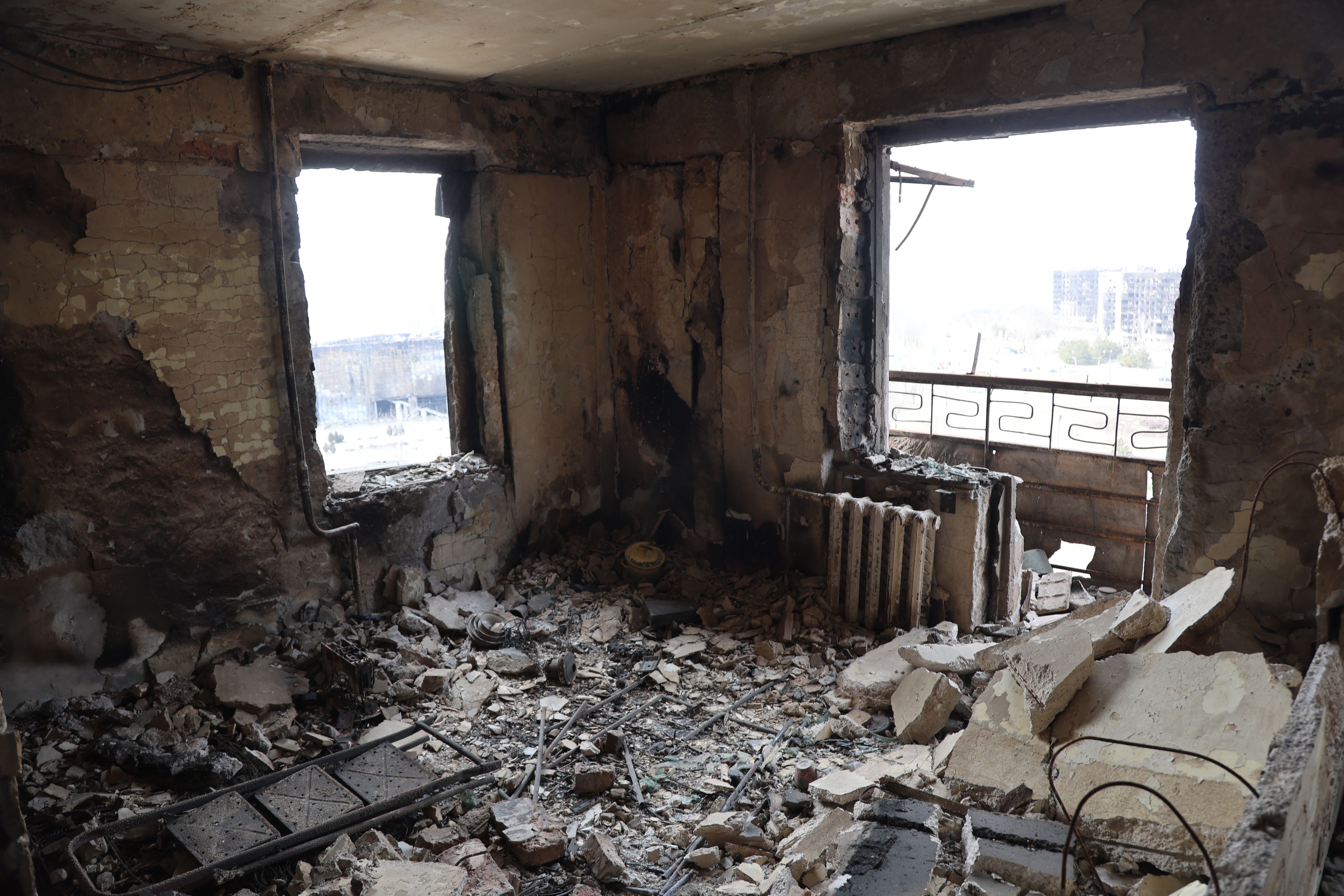 Veduta di edifici e veicoli danneggiati dopo il bombardamento della città ucraina di Mariupol il 29 marzo, controllata dall'esercito russo e dai separatisti filo-russi.