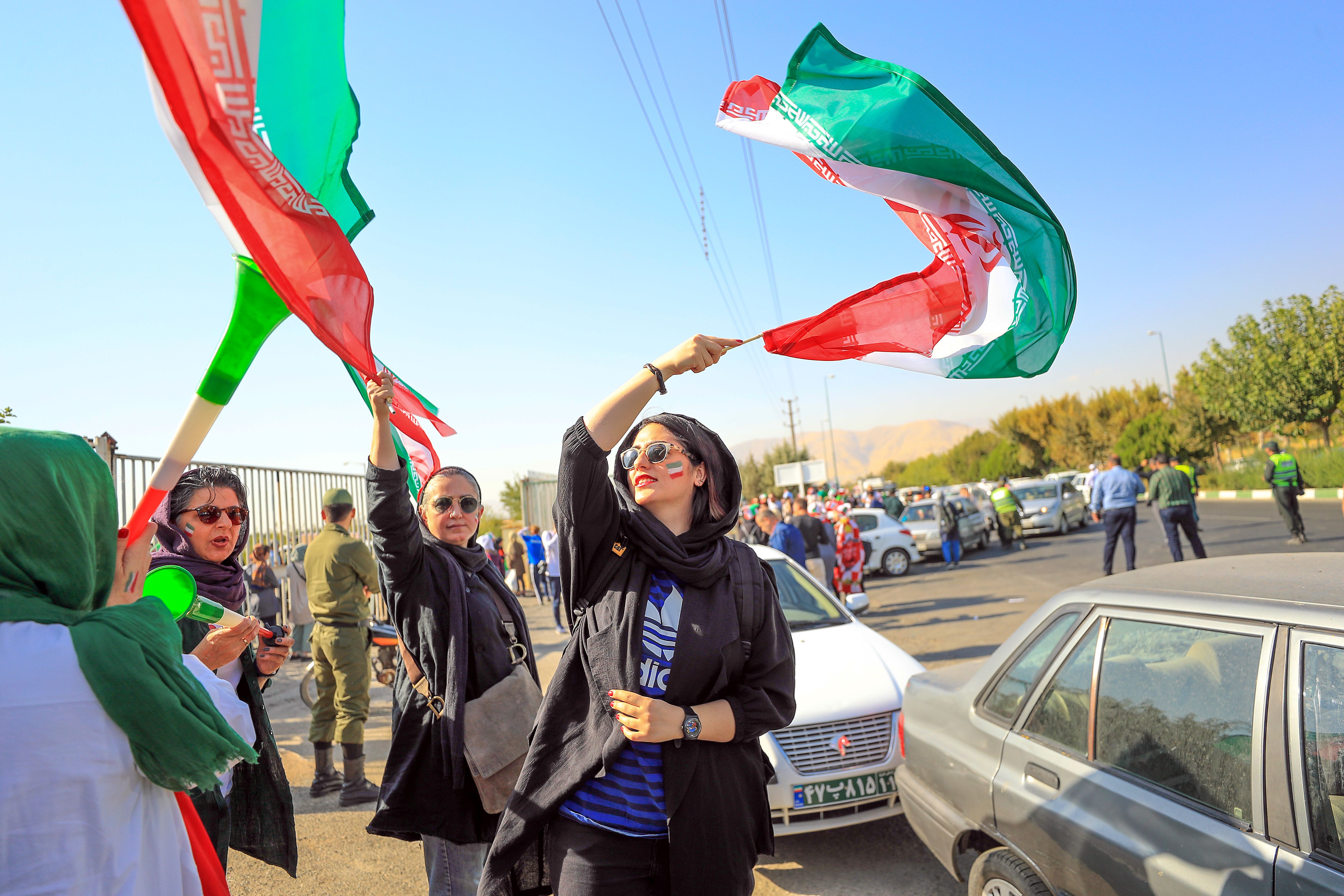 Women cheer in the streets of Tehran before a soccer game
