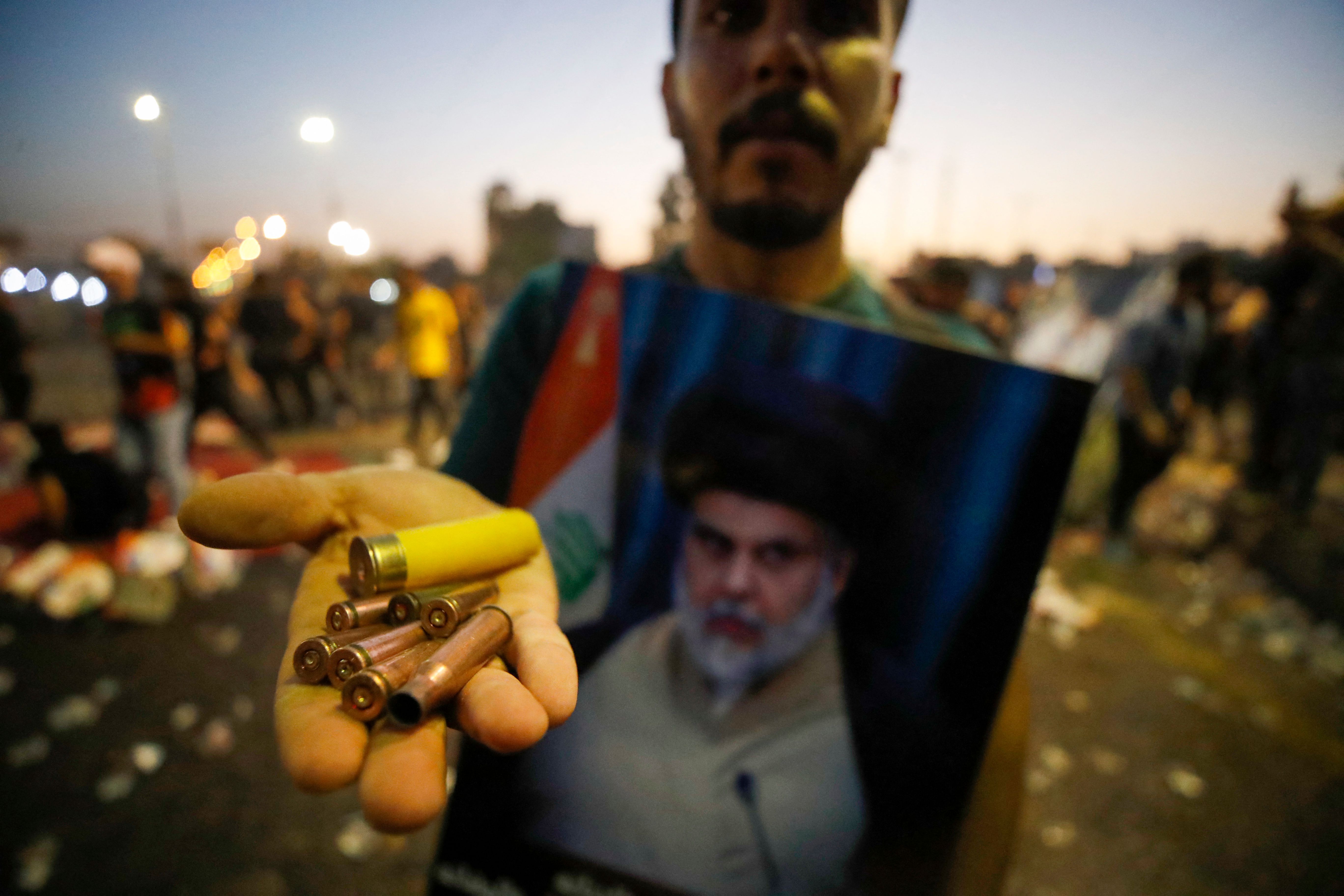A supporter of Iraqi Shiite cleric Moqtada Sadr carries bullet casings and a spent shotgun shell in the capital Baghdad, on August 29.