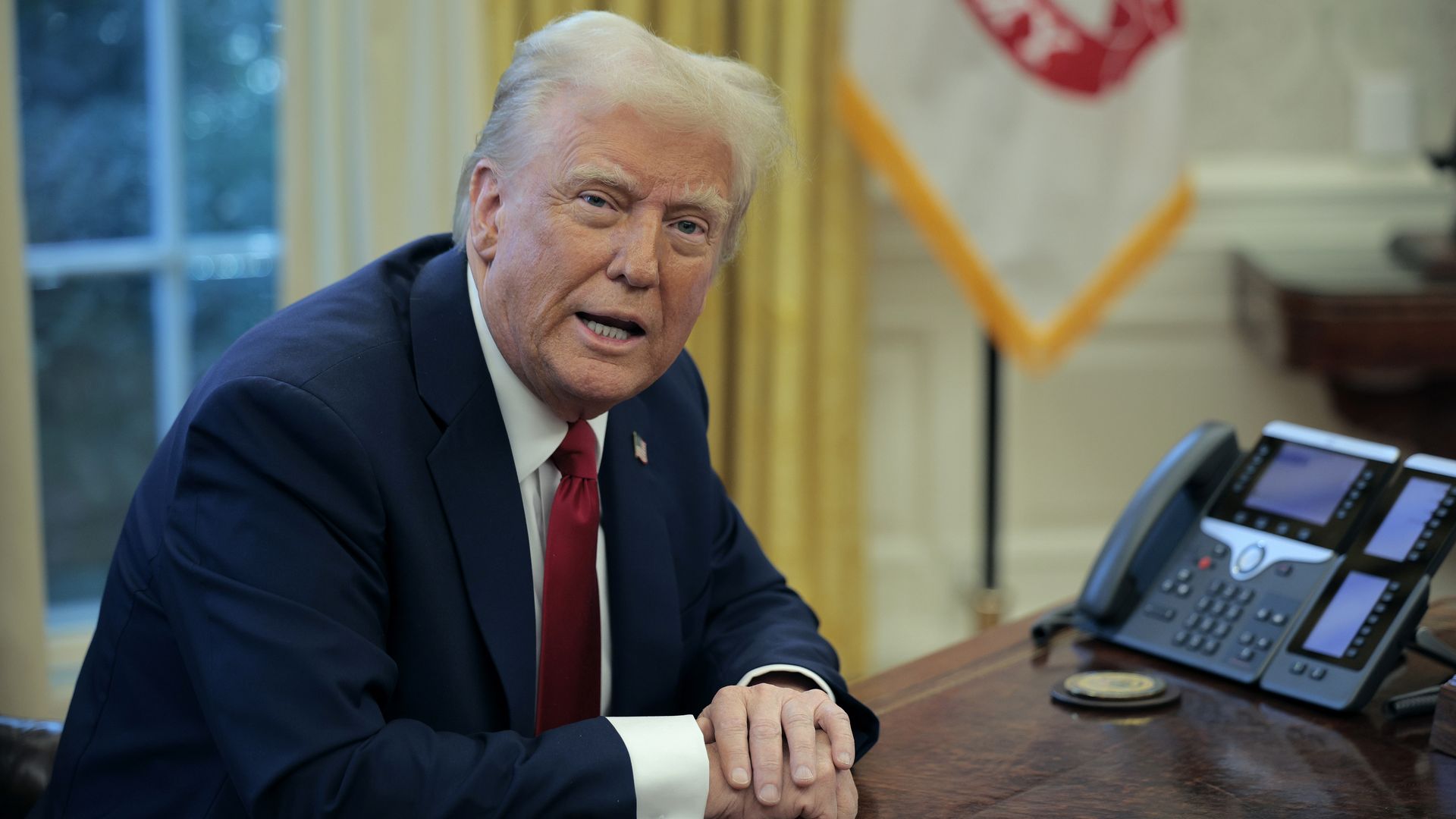 President Donald Trump talks to reporters from the Resolute Desk after signing a memo ordering an immediate assessment of aviation safety and ordering an elevation of what he called "competence" over "D.E.I." 