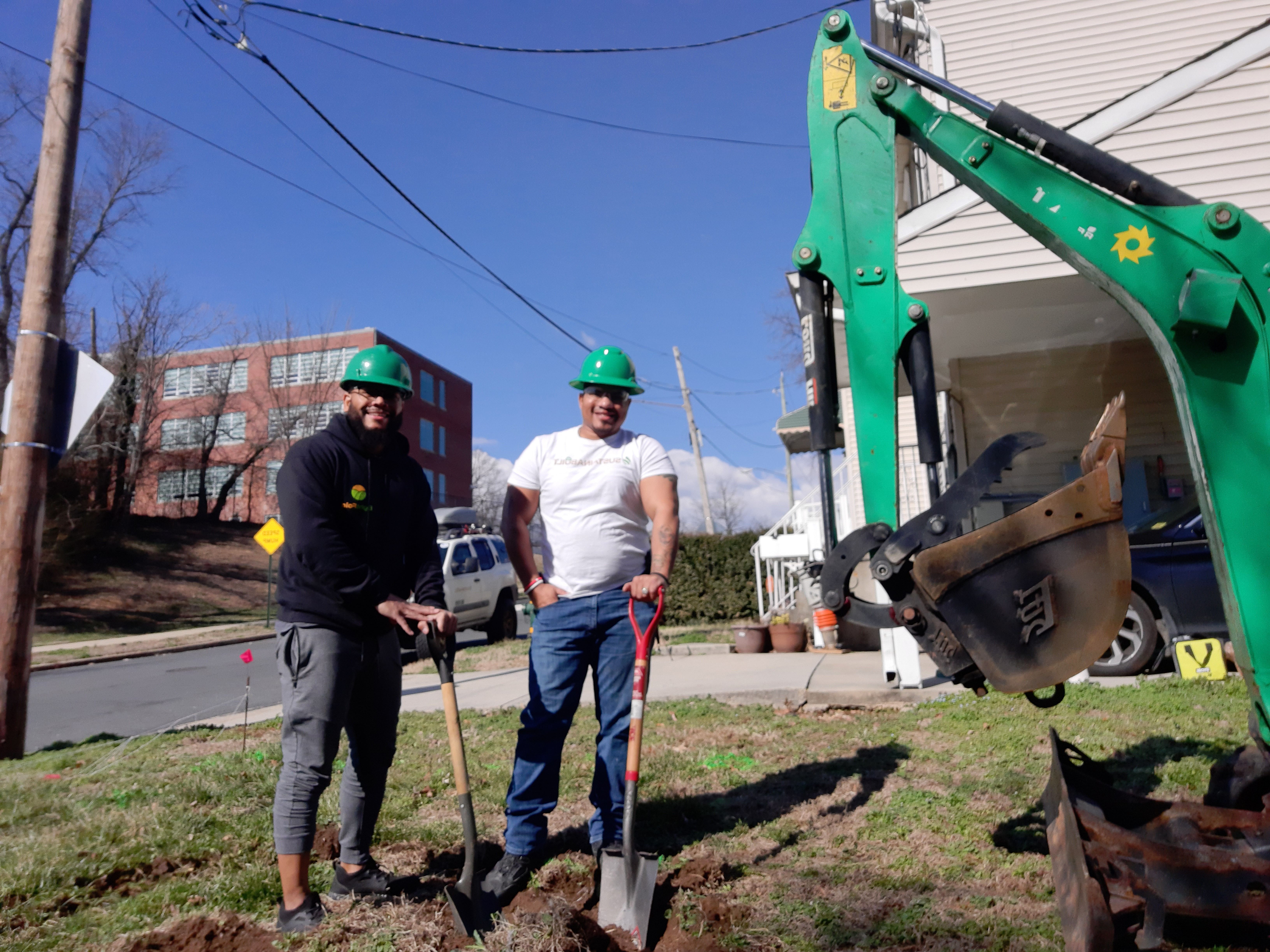 Two men next to an excavator