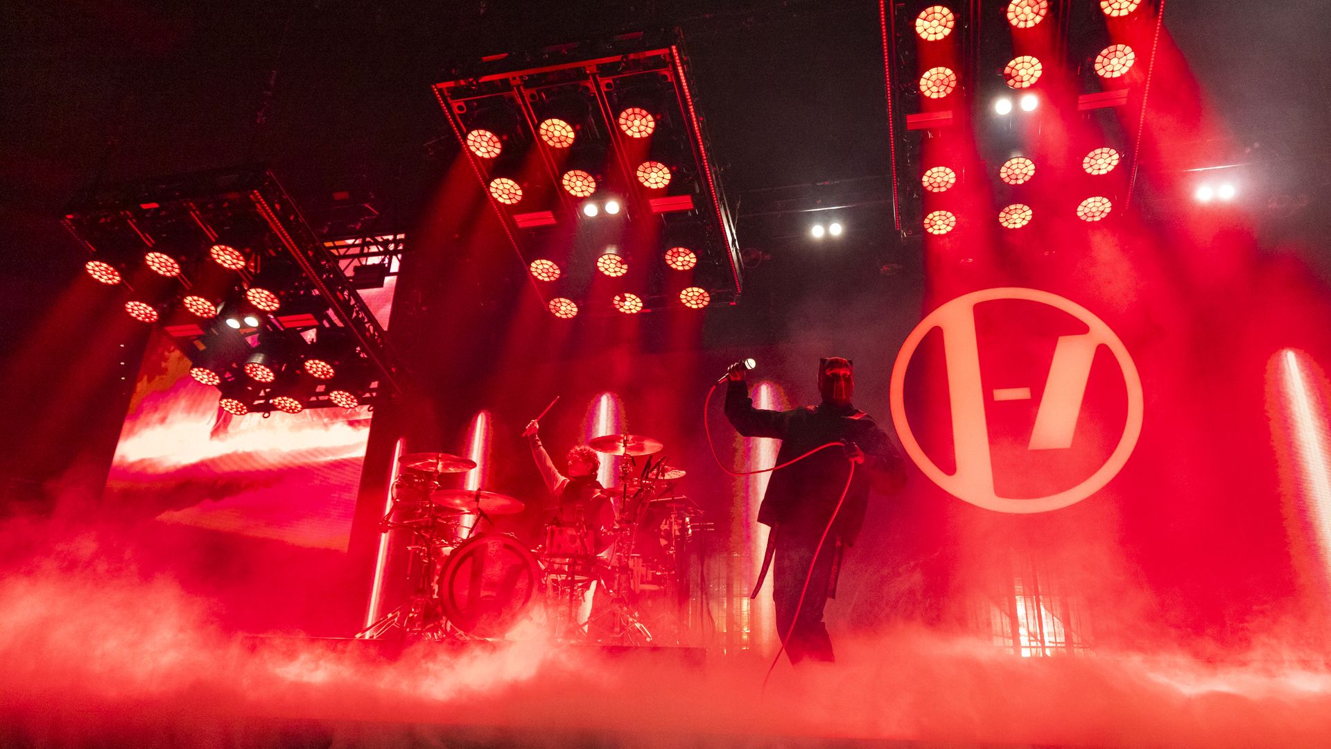 A Twenty One Pilots concert with red lighting and stage smoke at Little Caesars Arena