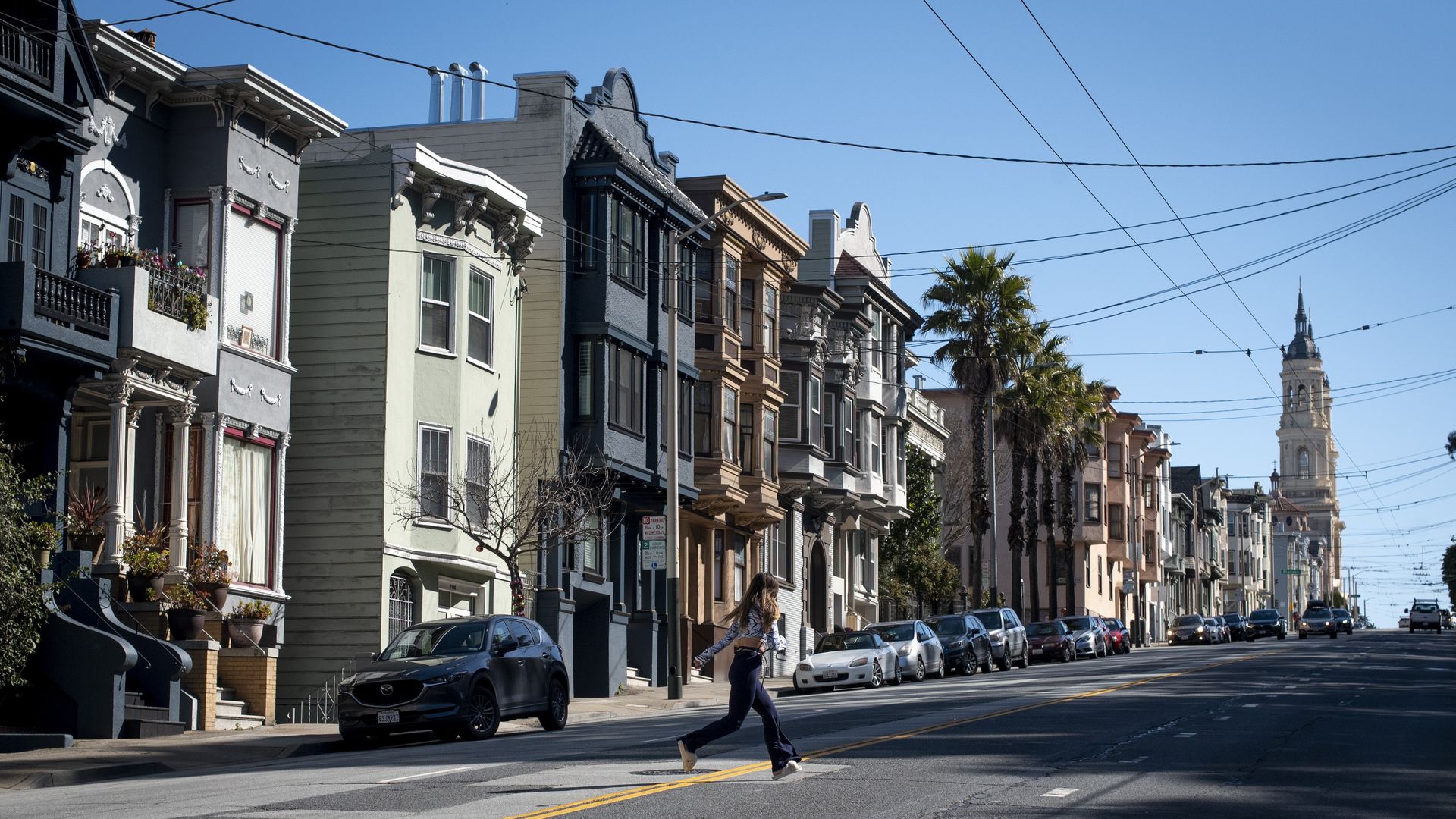 someone jaywalks in front of apartment buildings 