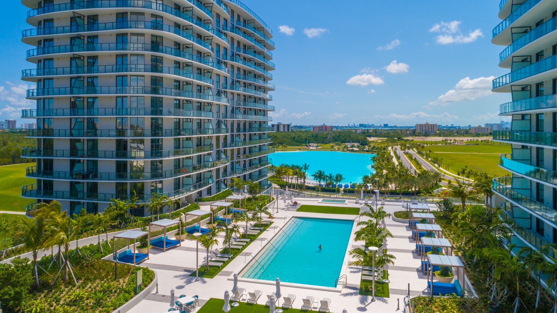 A luxury condominium and turquoise swimming pool.