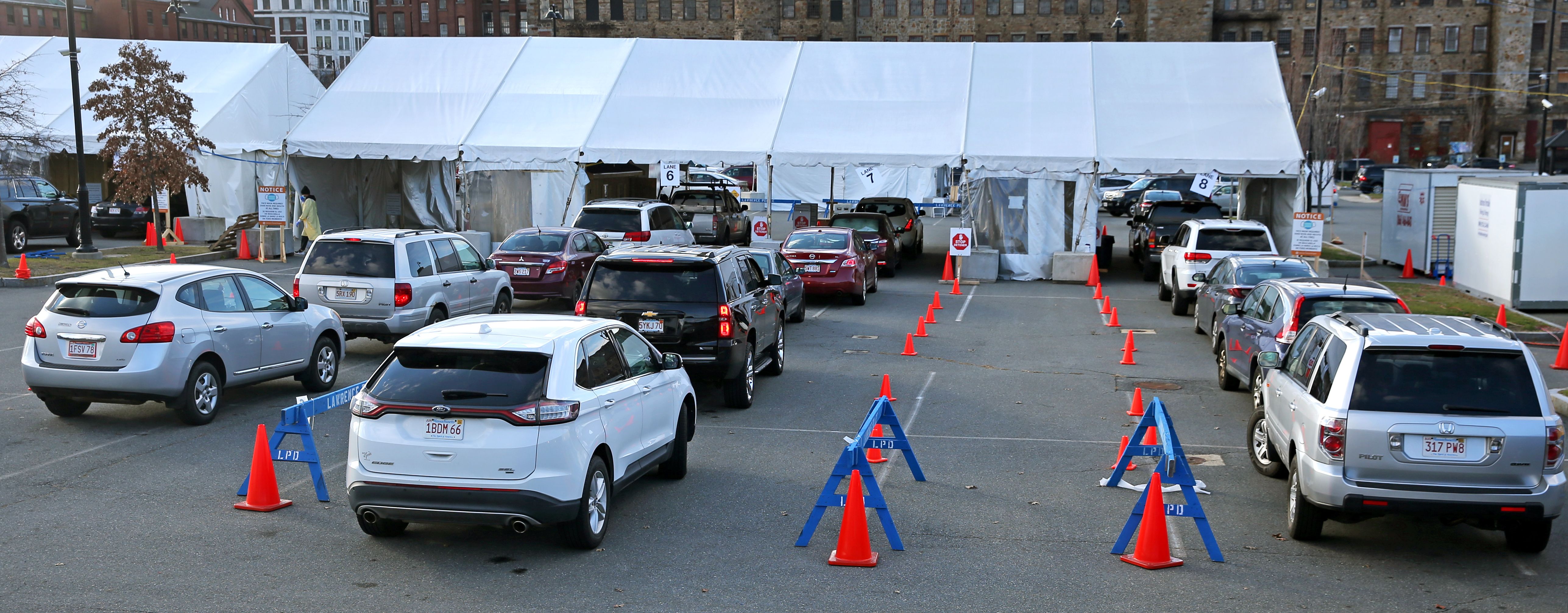 Picture of cars lining up in front of a white tent to get tested for coronavirus in Lawrence, MA