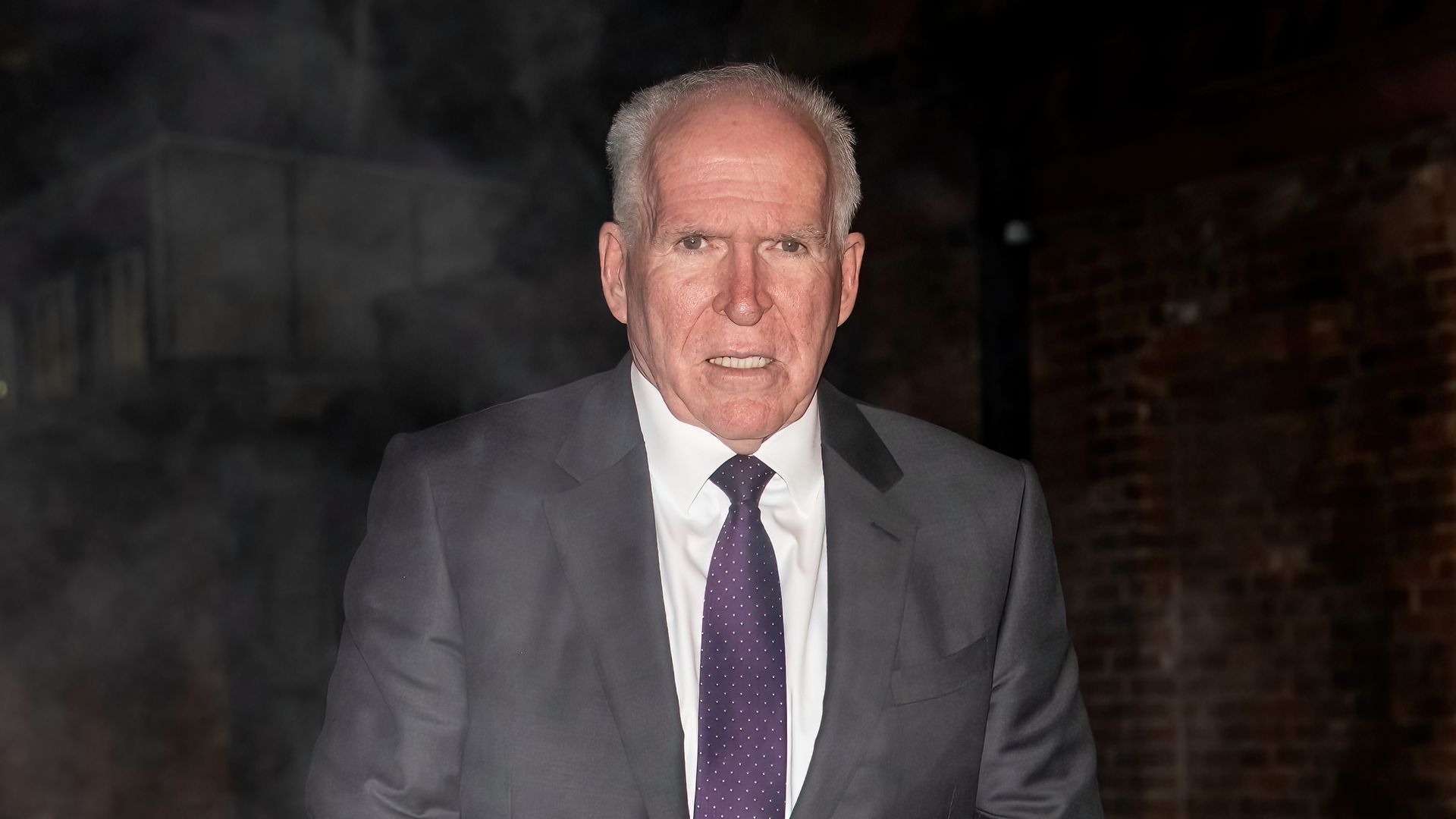 John Brennan wearing a grey jacket, white shirt and purple tie