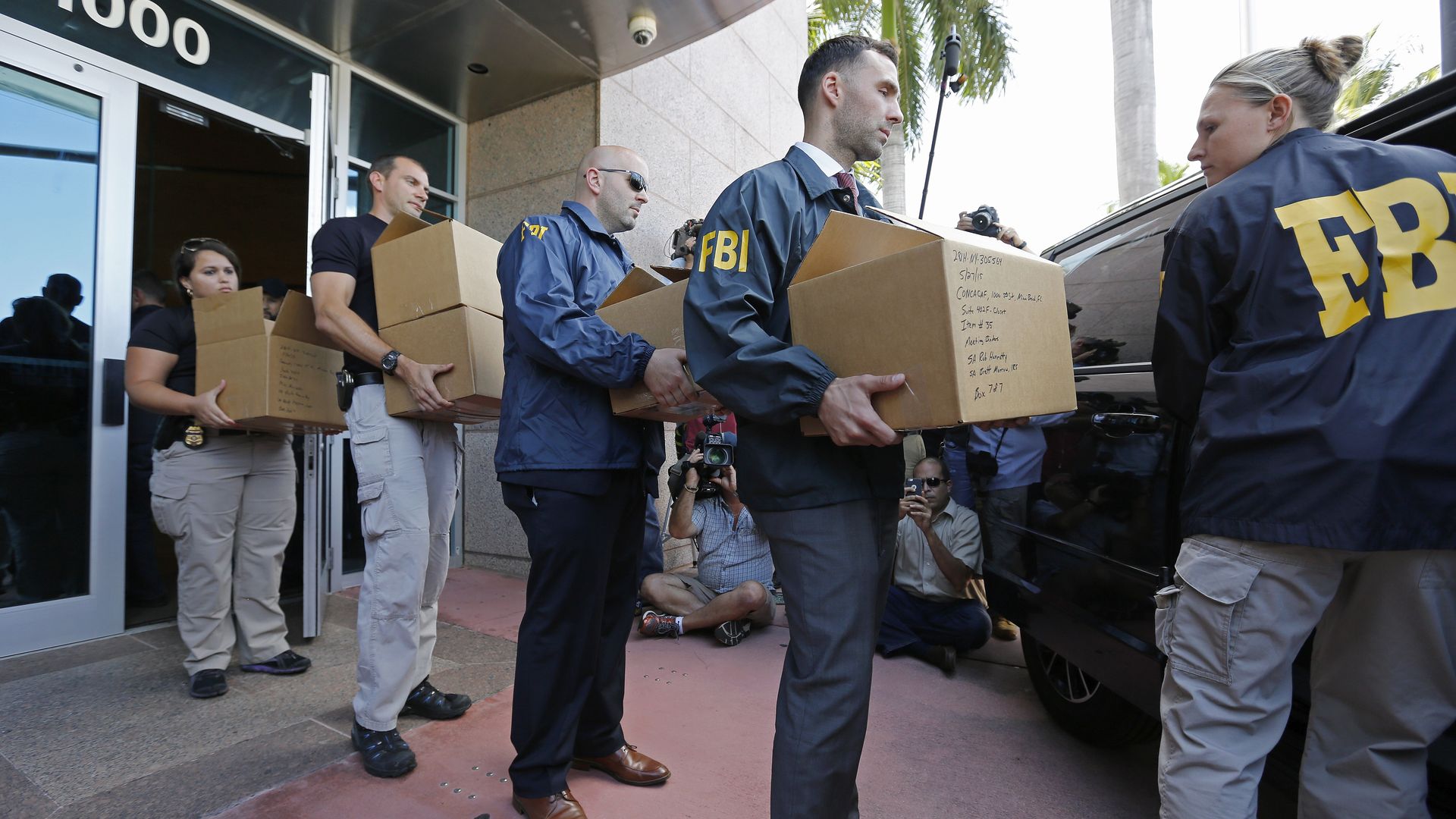 FBI agents carrying boxes