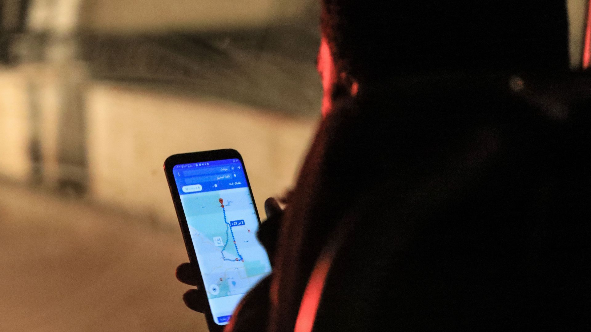 Photo of a Syrian man checking a phone map after being evacuated from Eastern Ghouta