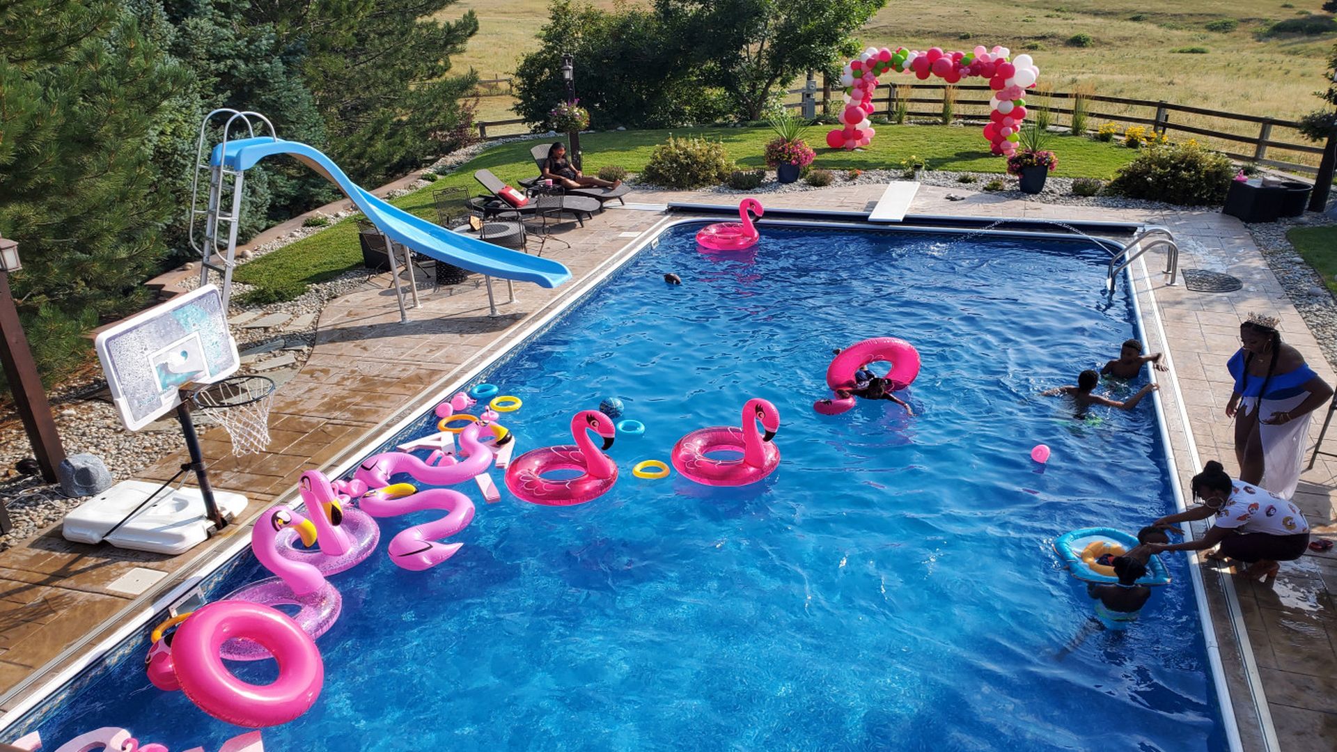 backyard pool with lots of pink floaties