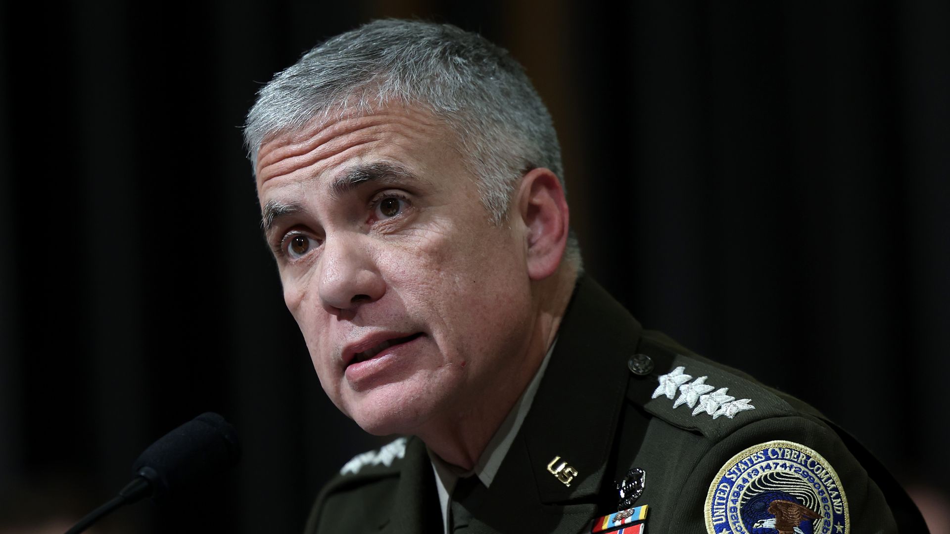 Gen. Paul Nakasone in front of a microphone while in uniform during a congressional hearing