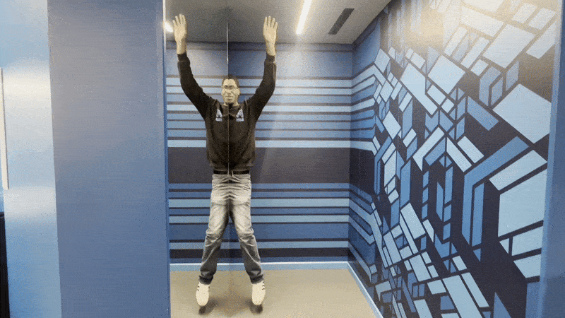 Image shows a man making an illusion with a mirror.