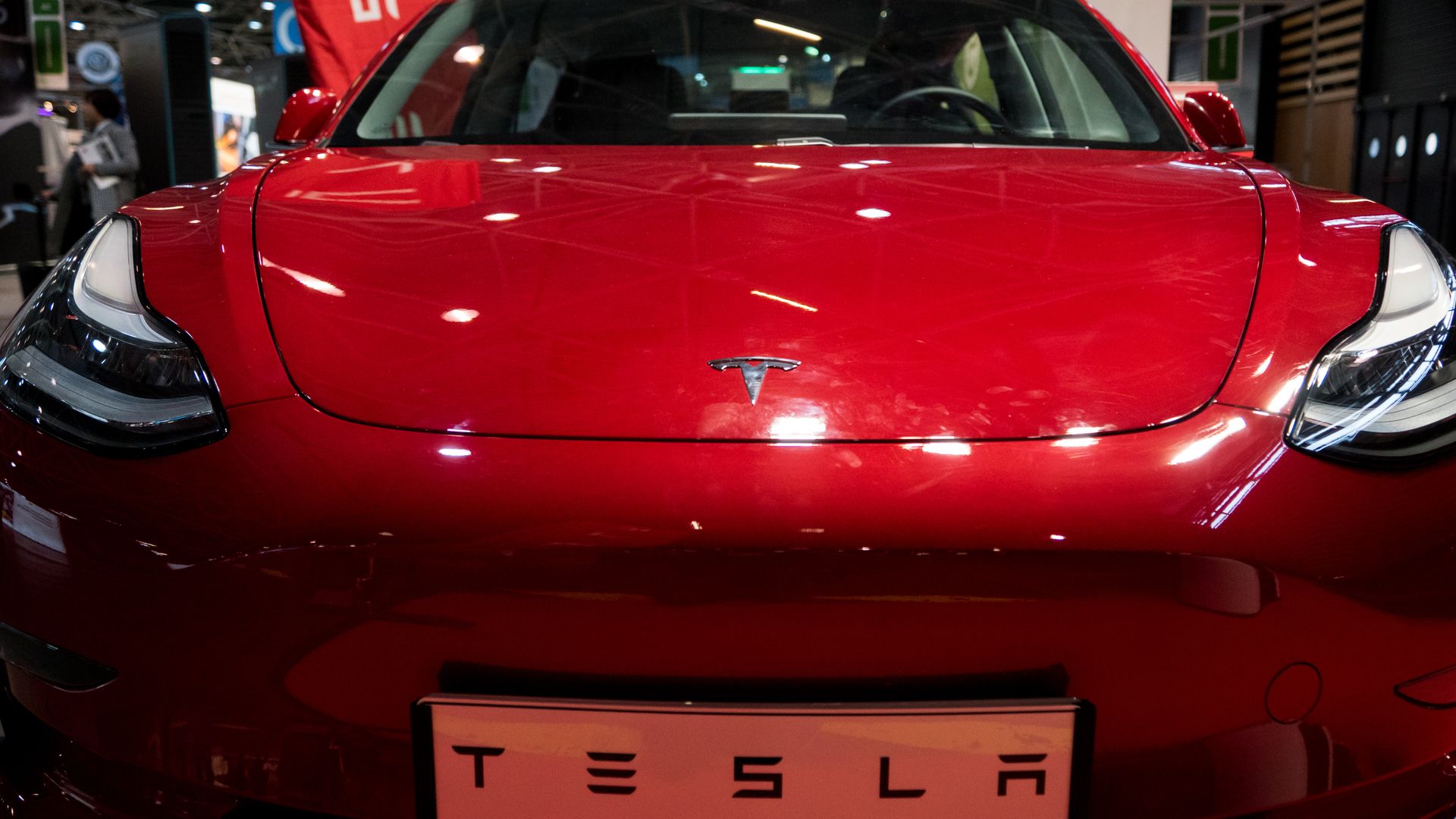 Photo of bright red Tesla in showroom