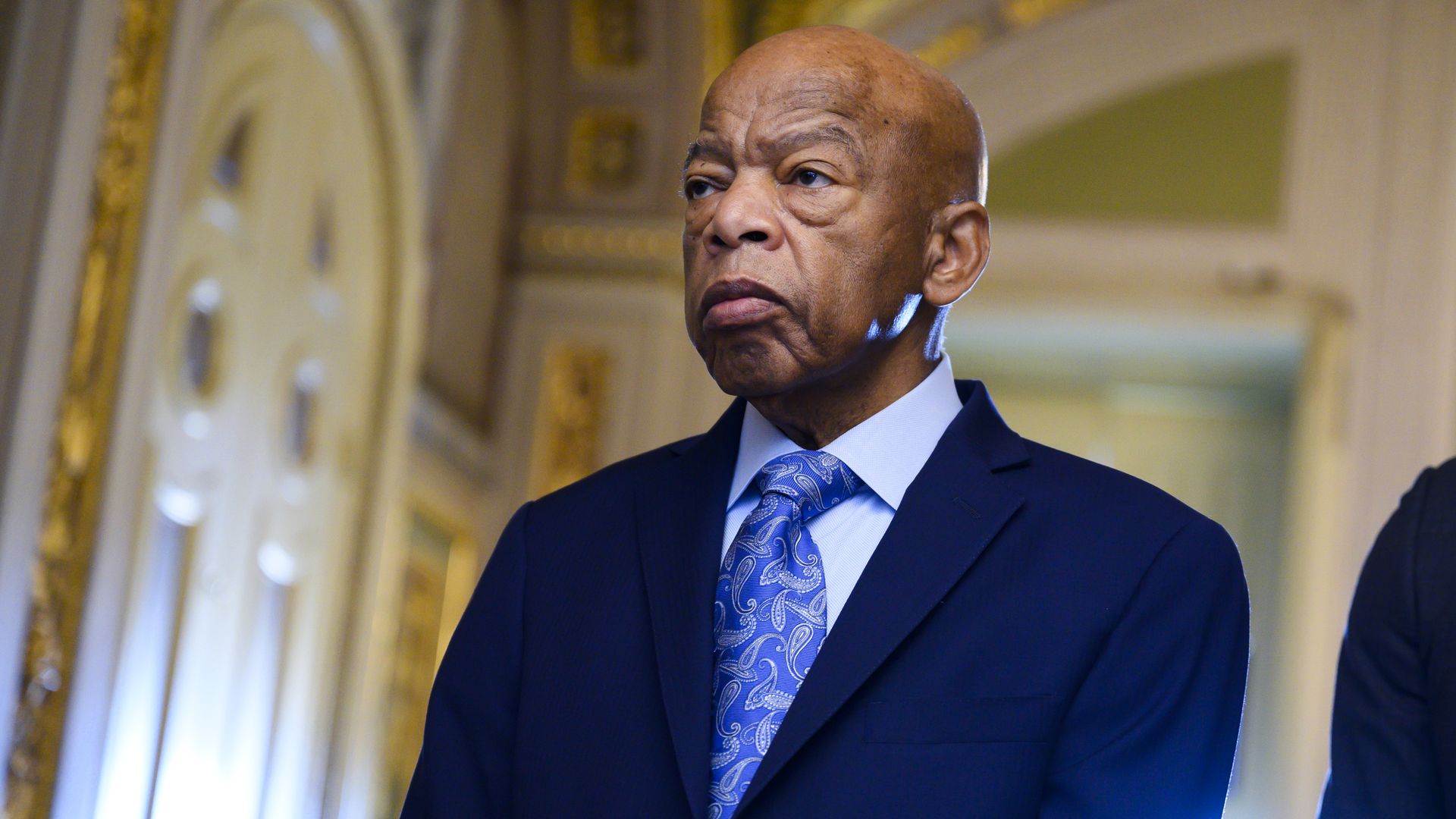 John Lewis stands in a suit and tie 