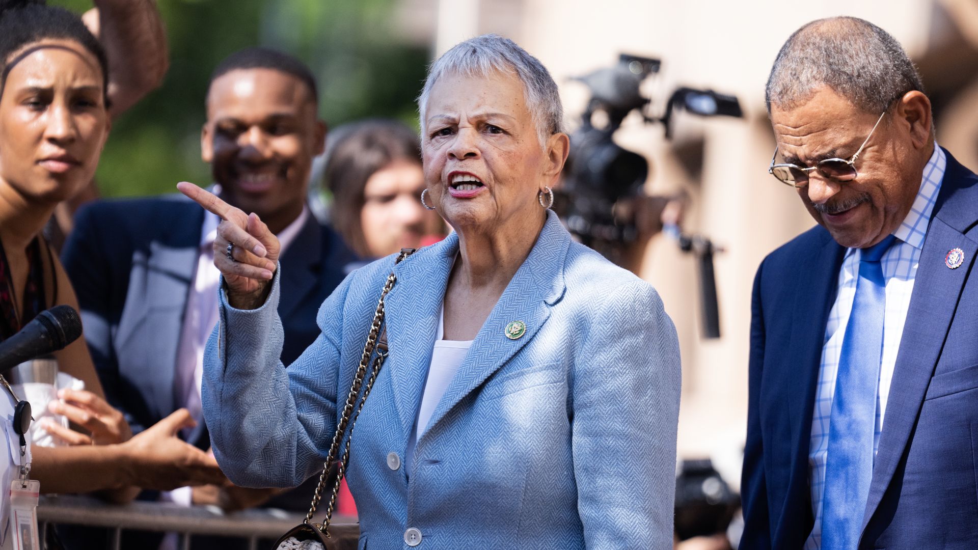 Rep. Bonnie Watson Coleman, wearing a powder blue jacket and speaking to reporters outside.
