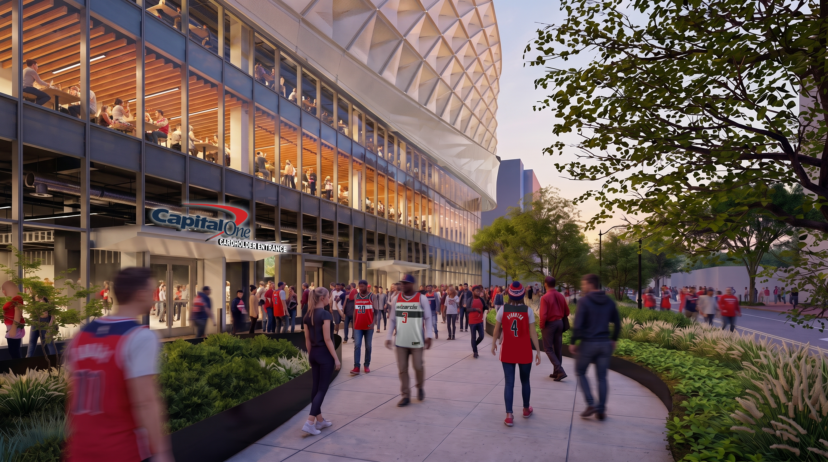 Exterior view of a modern stadium with glass walls and a white lattice facade. Crowds in red jerseys gather outside near trees; a Capital One Cardholder Entrance sign is visible.