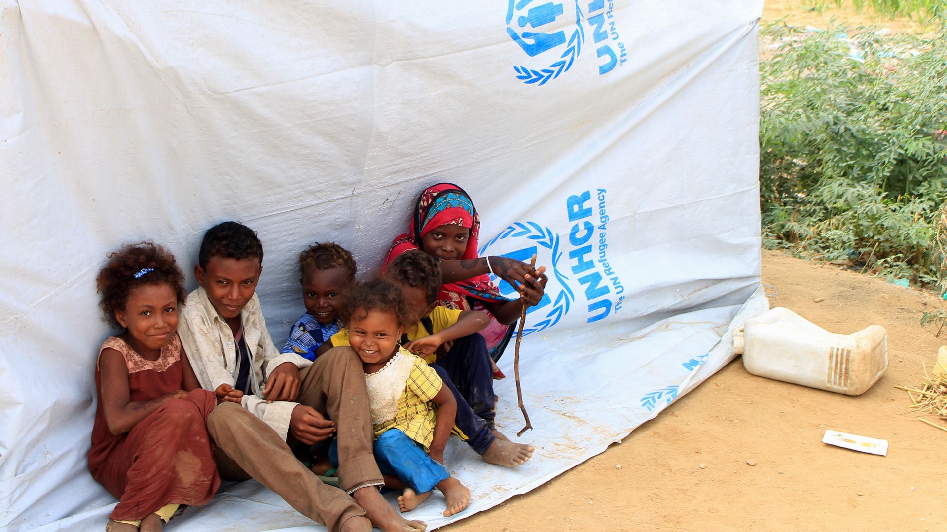displaced Yemeni children sitting on a tarp
