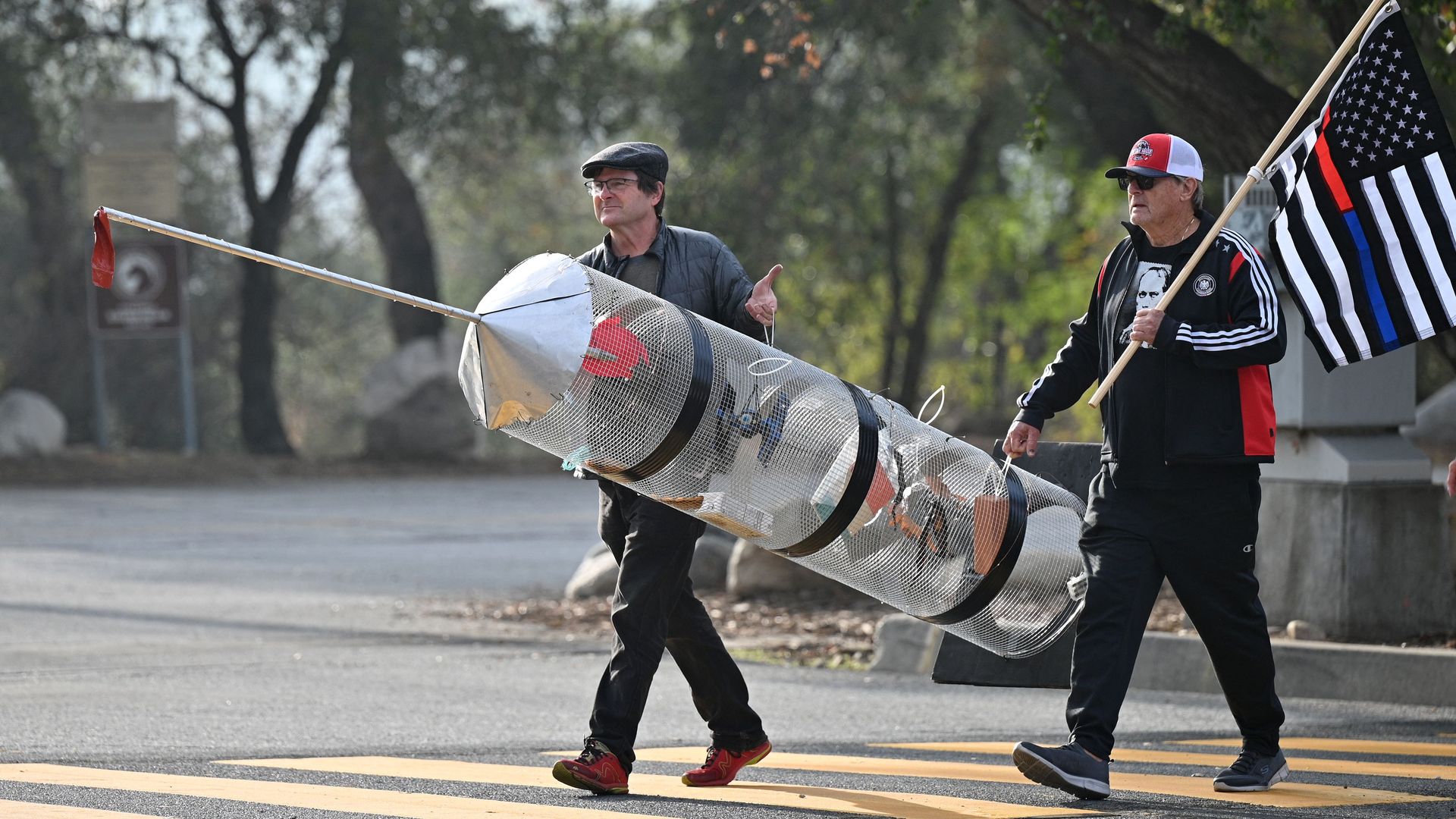 Federal workers are seen toting a mock syringe as they protest the government's COVID-19 vaccine mandate.