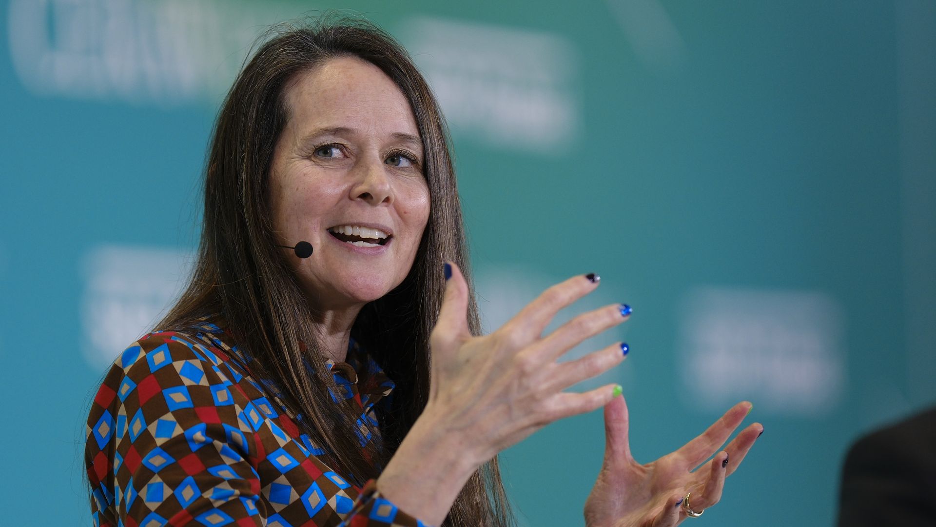 Jen Easterly, then-director of the Cybersecurity and Infrastructure Security Agency, speaking on a stage with a microphone. 