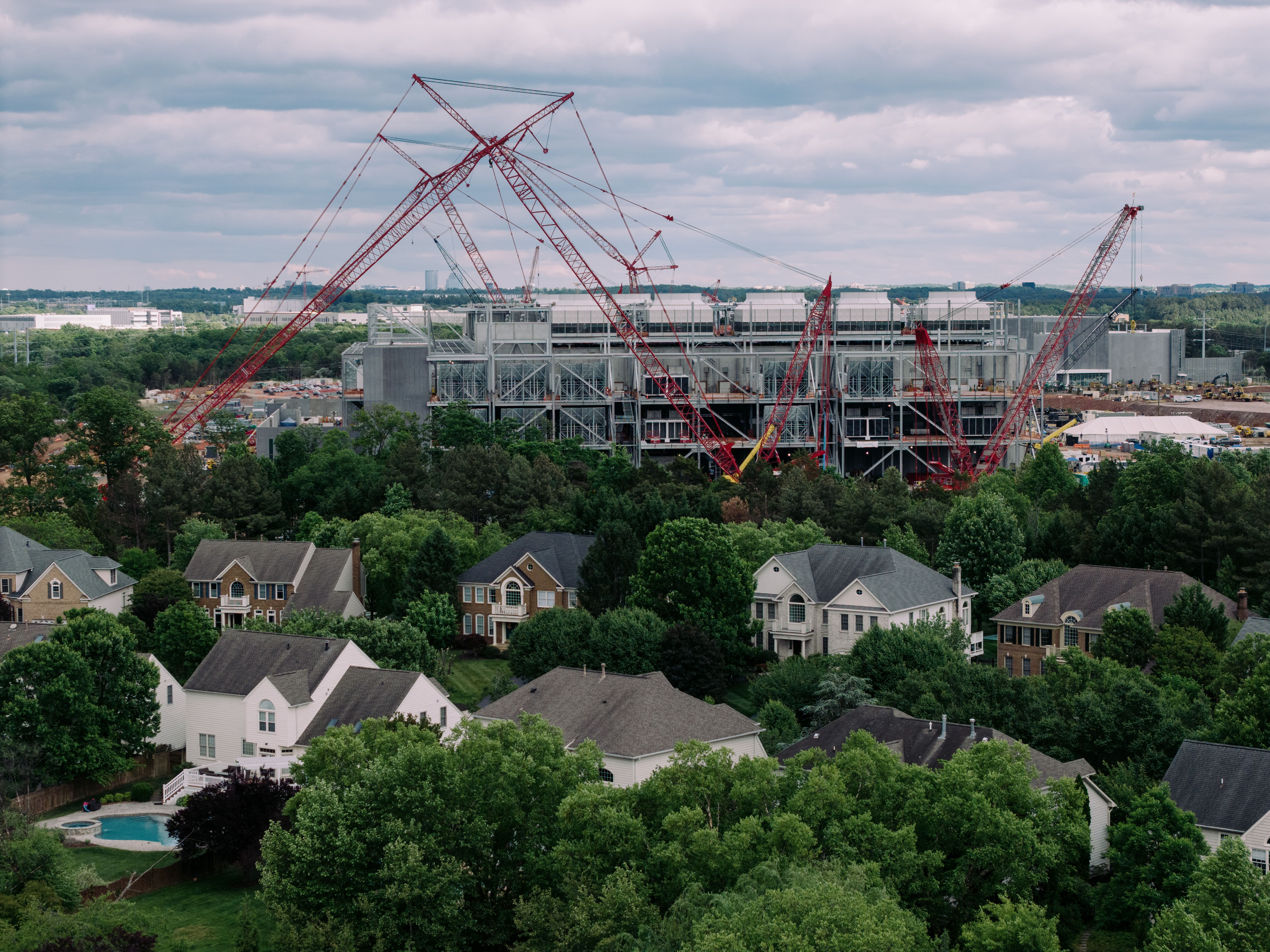 A series of homes with a data center under construction in the background.