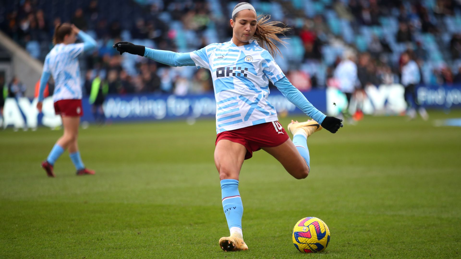 Photo of Deyna Castellanos with her left leg pulled back mid-kick during practice on a soccer field