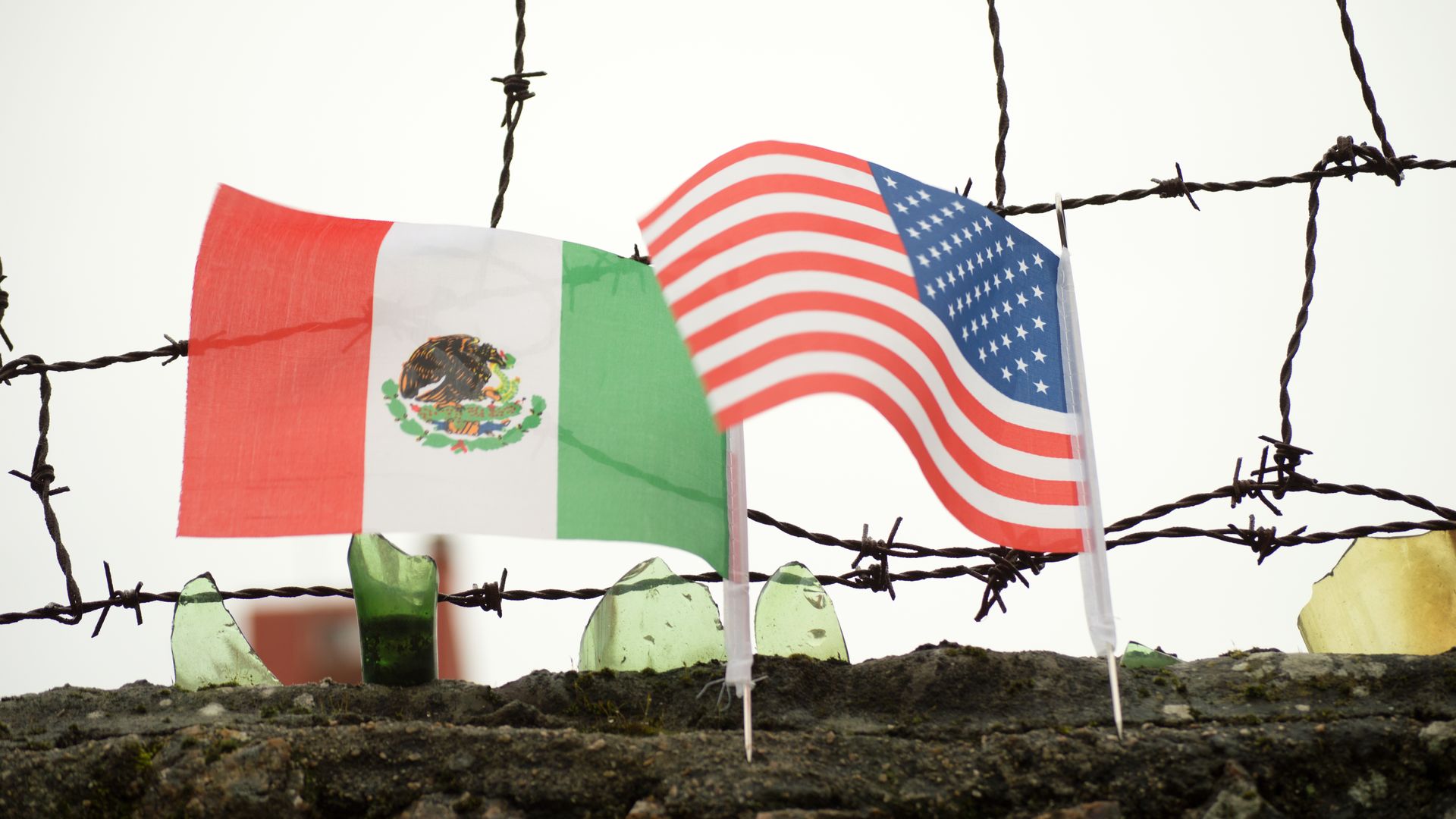 Mexican and American flags planted in soil