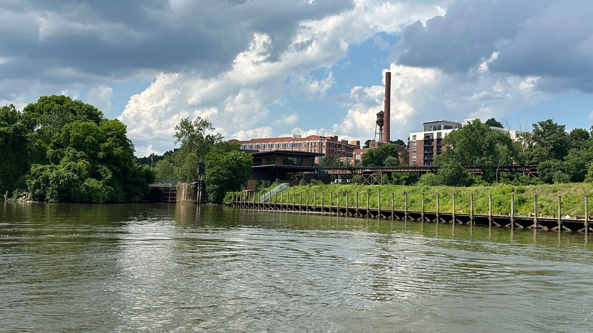 A view of the river, a dock and a building in the background