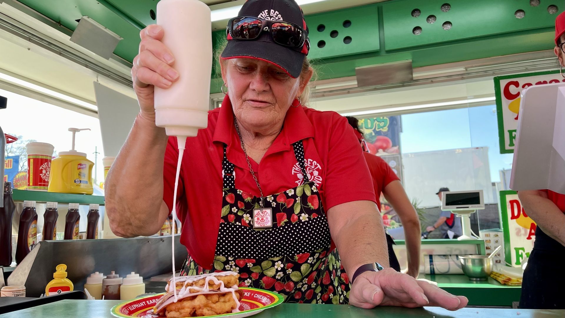 Mama Jane Harris squirts a bottle of donut glaze on a funnel cake Cuban sandwich at the Florida State Fair in February.