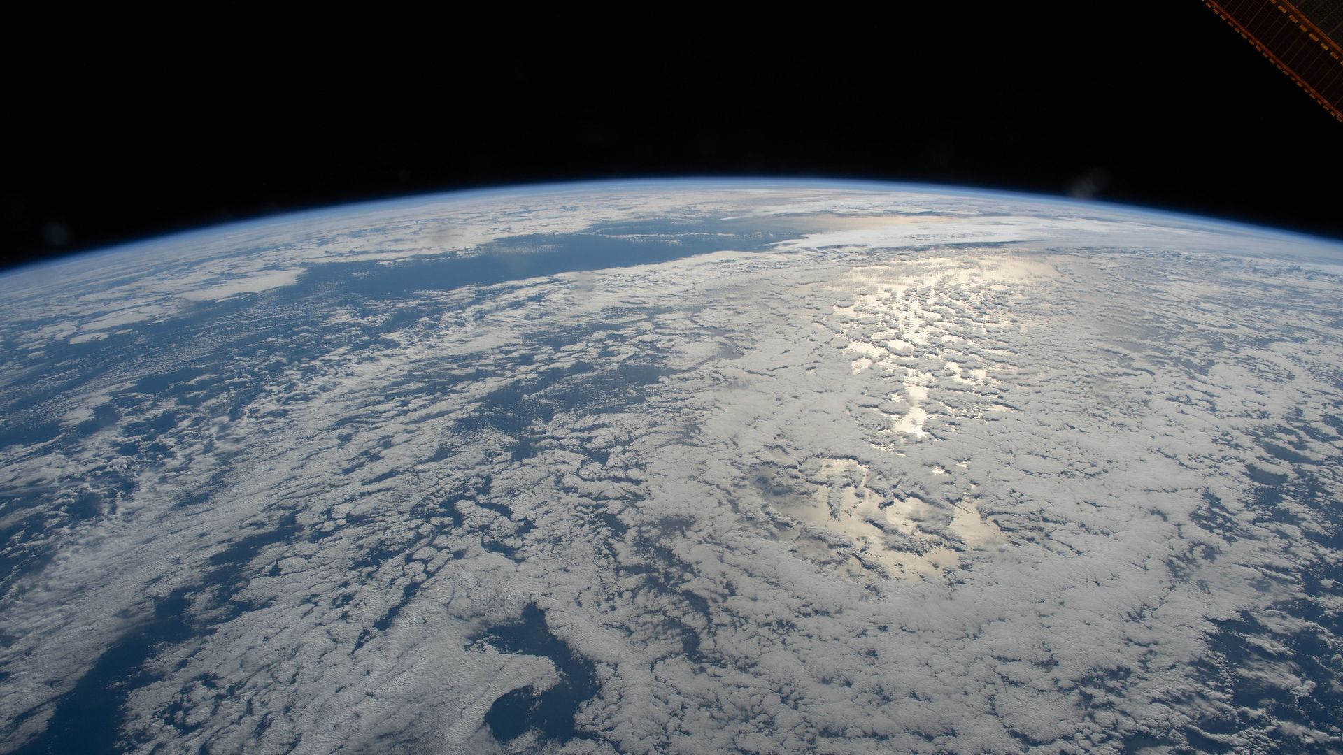 A photo taken from orbit of the Sun glinting off the ocean