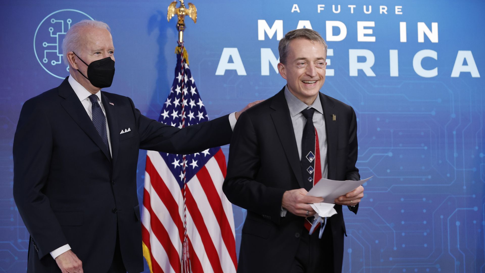 President Biden with Intel's CEO, in front of an American flag and "A Future Made In America" written on the wall. 