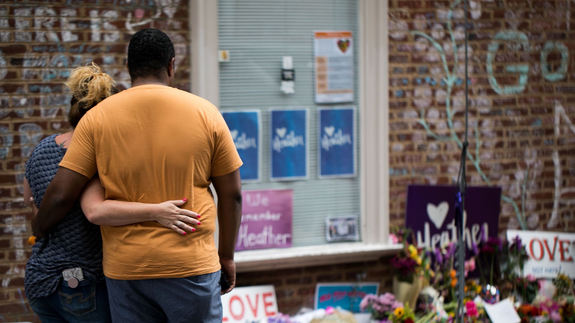 A couple looking at a memorial to Heather Heyer