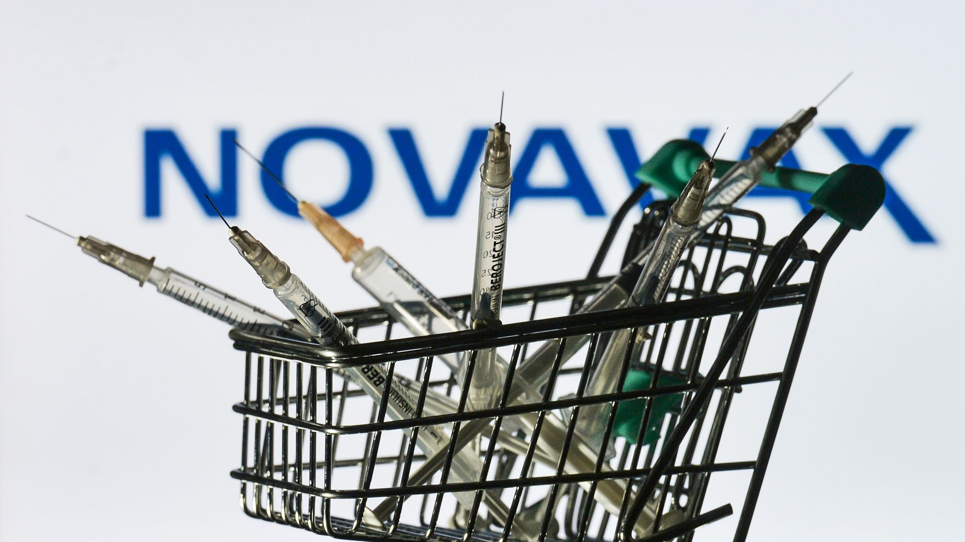 Syringes in front of a Novavax screen.
