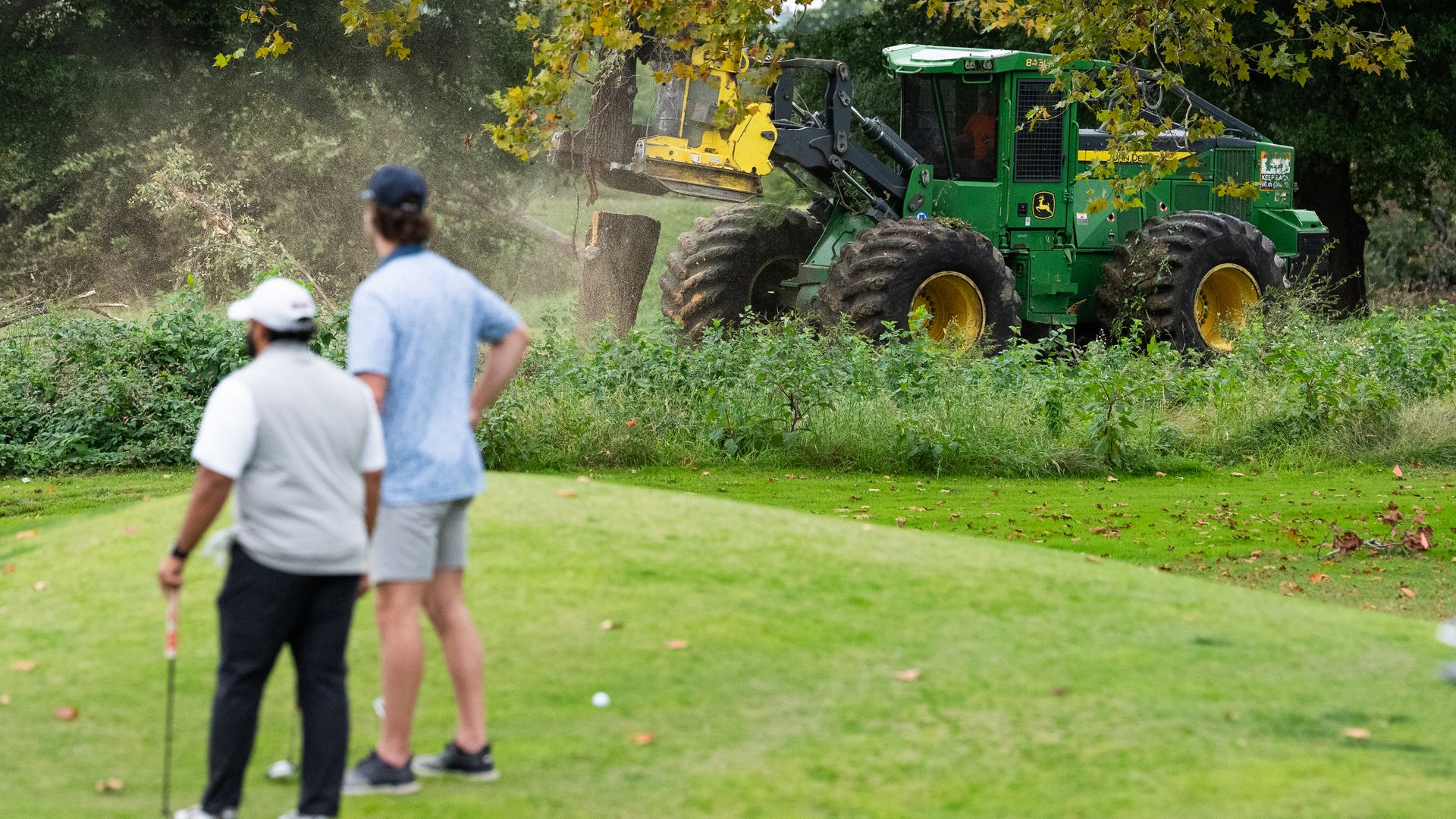 Golfers look on as crews cut trees at East Potomac golf course