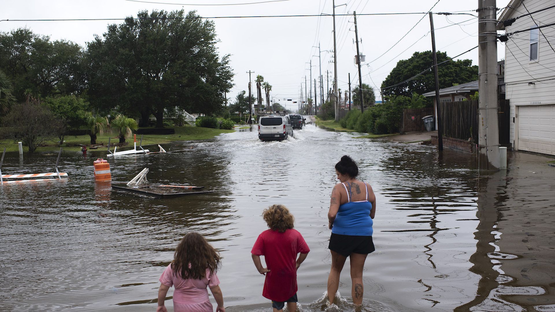 Zailey Segura, Zavery Segura and their mother Karen Smith wade through flood waters after Hurricane Nicholas landed in Galveston, Texas on September 14, 2021. Photo: Mark Felix/Getty Images