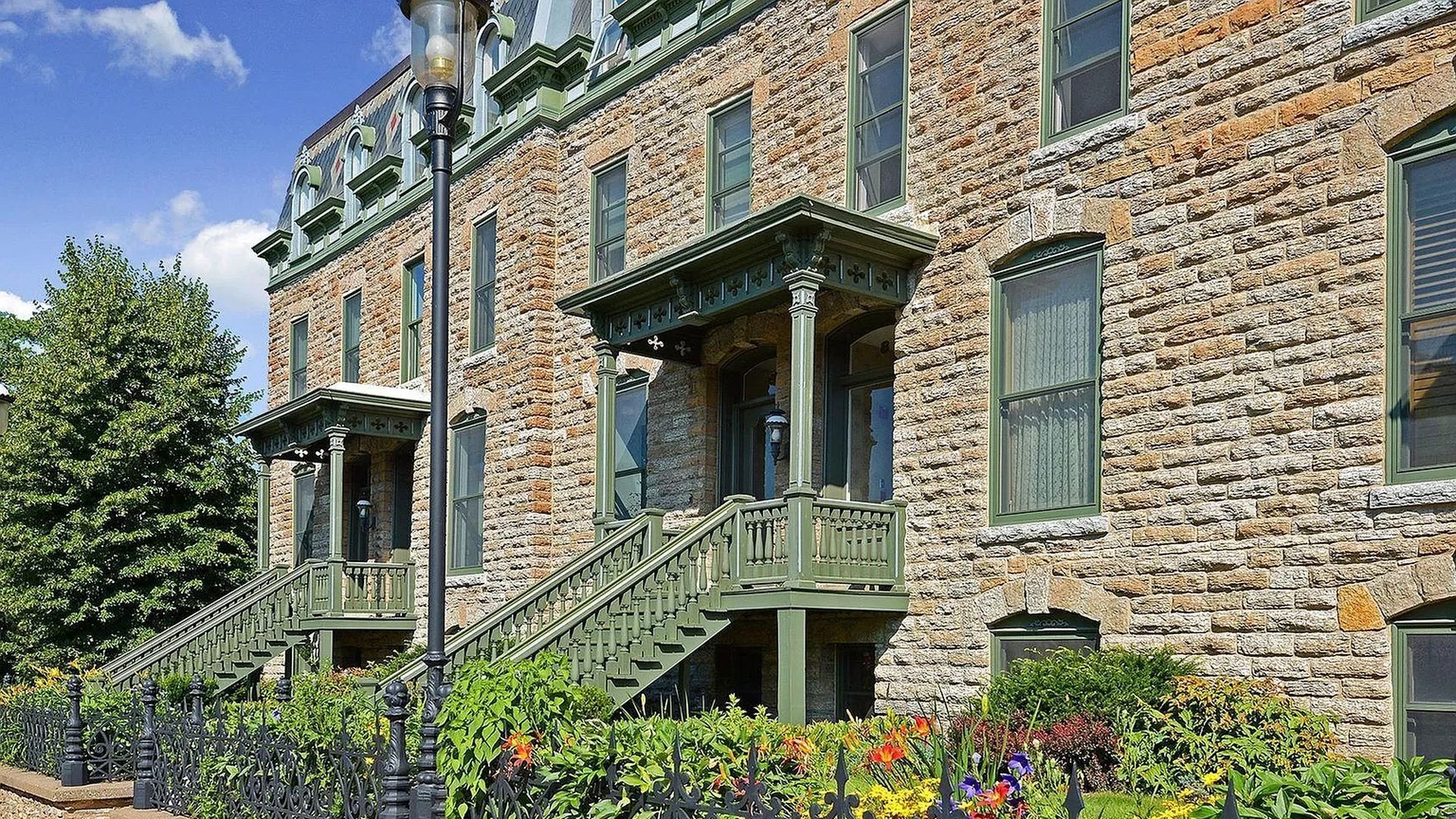 The exterior of a townhouse with flowers outside.