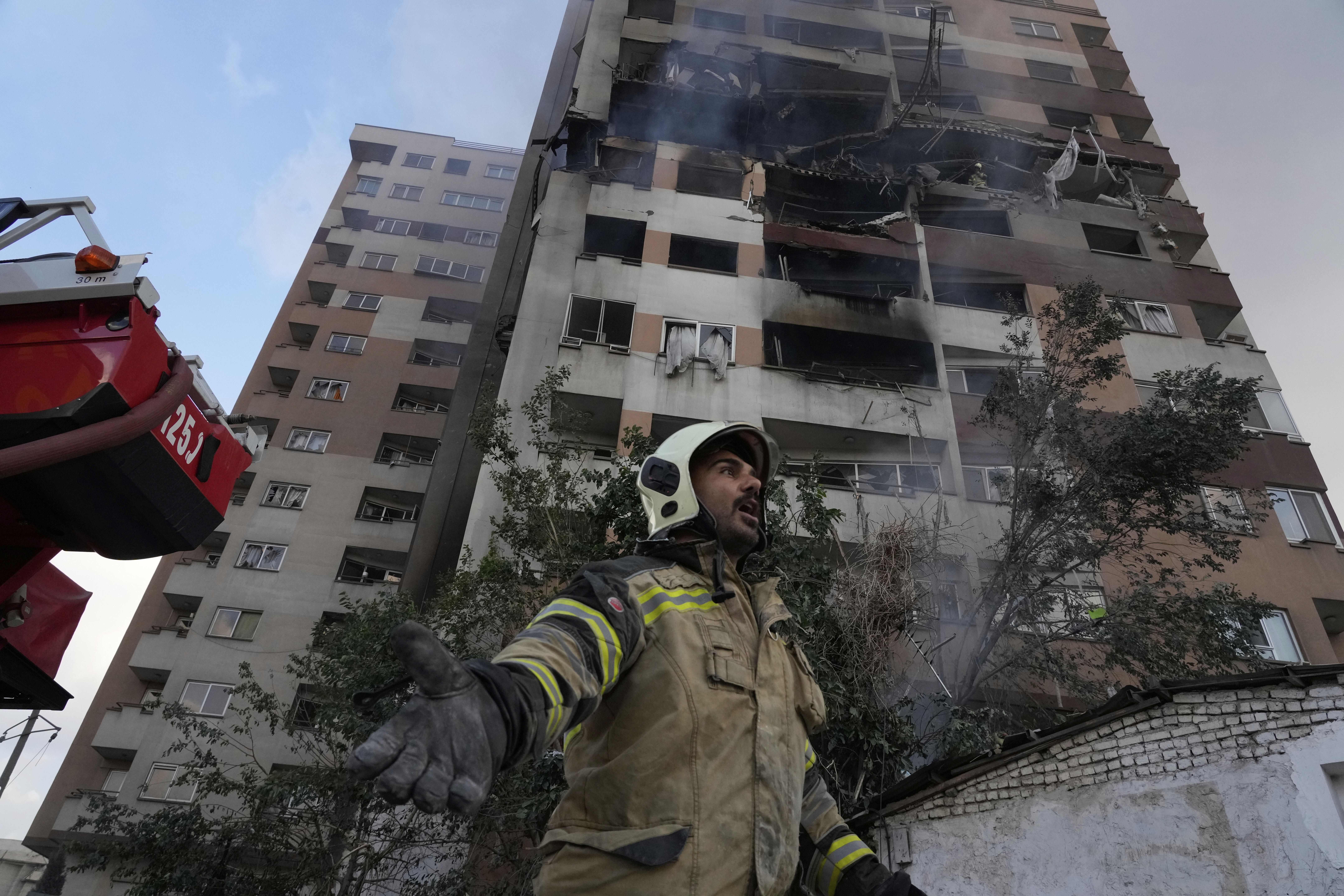 A firefighter calls for his colleagues at the scene of an explosion in northern Tehran.