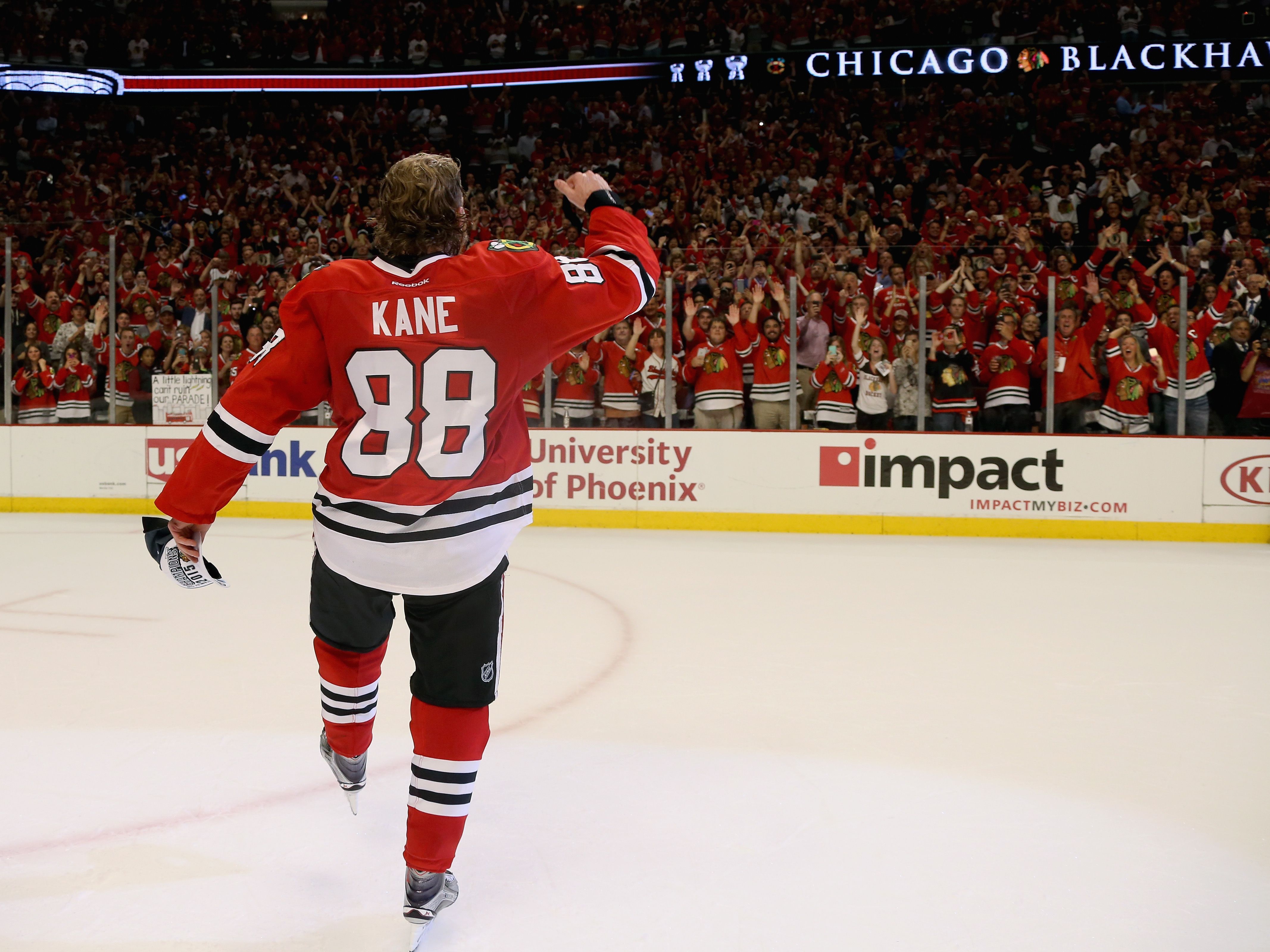 Hockey player with Kane on his shirt skating and waving 