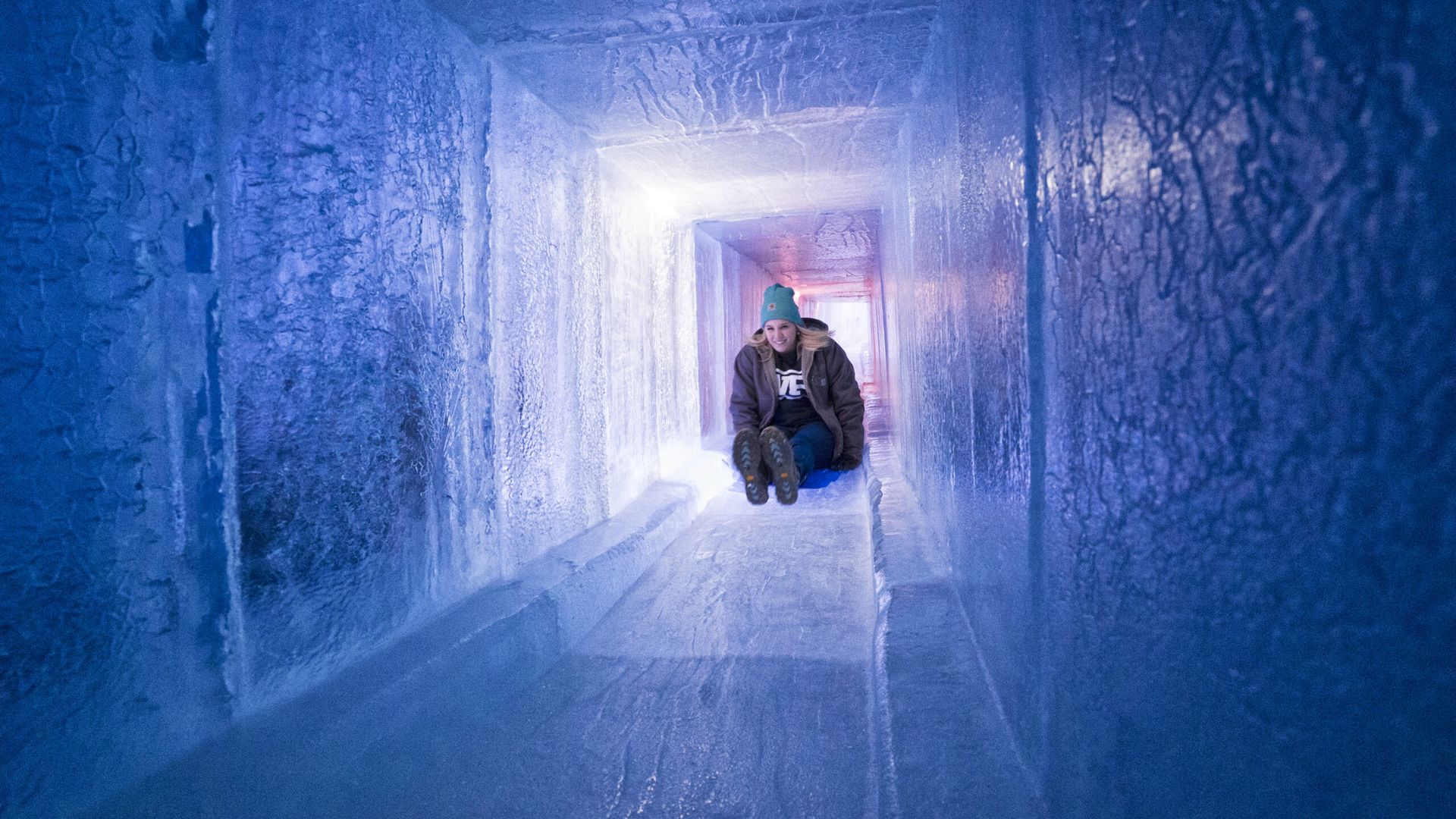 A photo of a woman going down an ice tunnel 